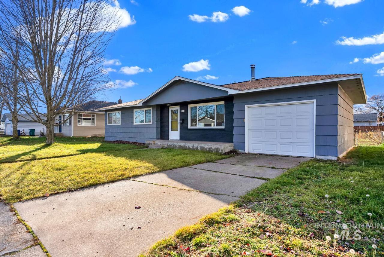 Ranch-style house with a garage, a front lawn, and concrete driveway