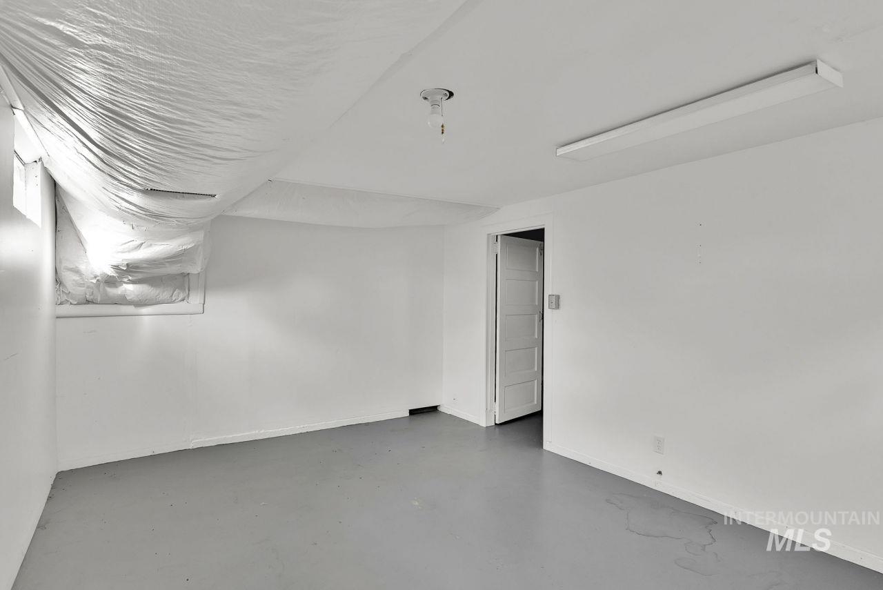 Unfurnished room with concrete flooring and baseboards