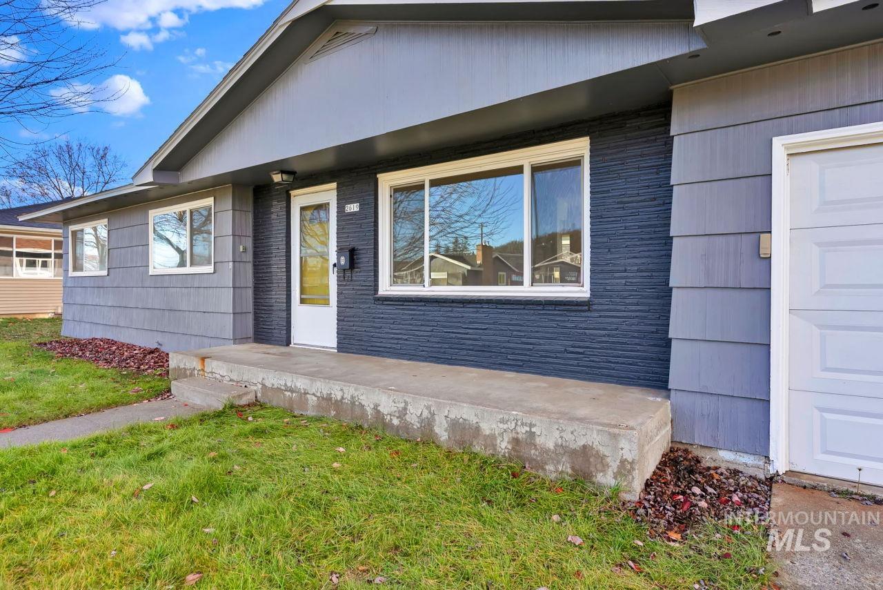 View of exterior entry featuring a lawn