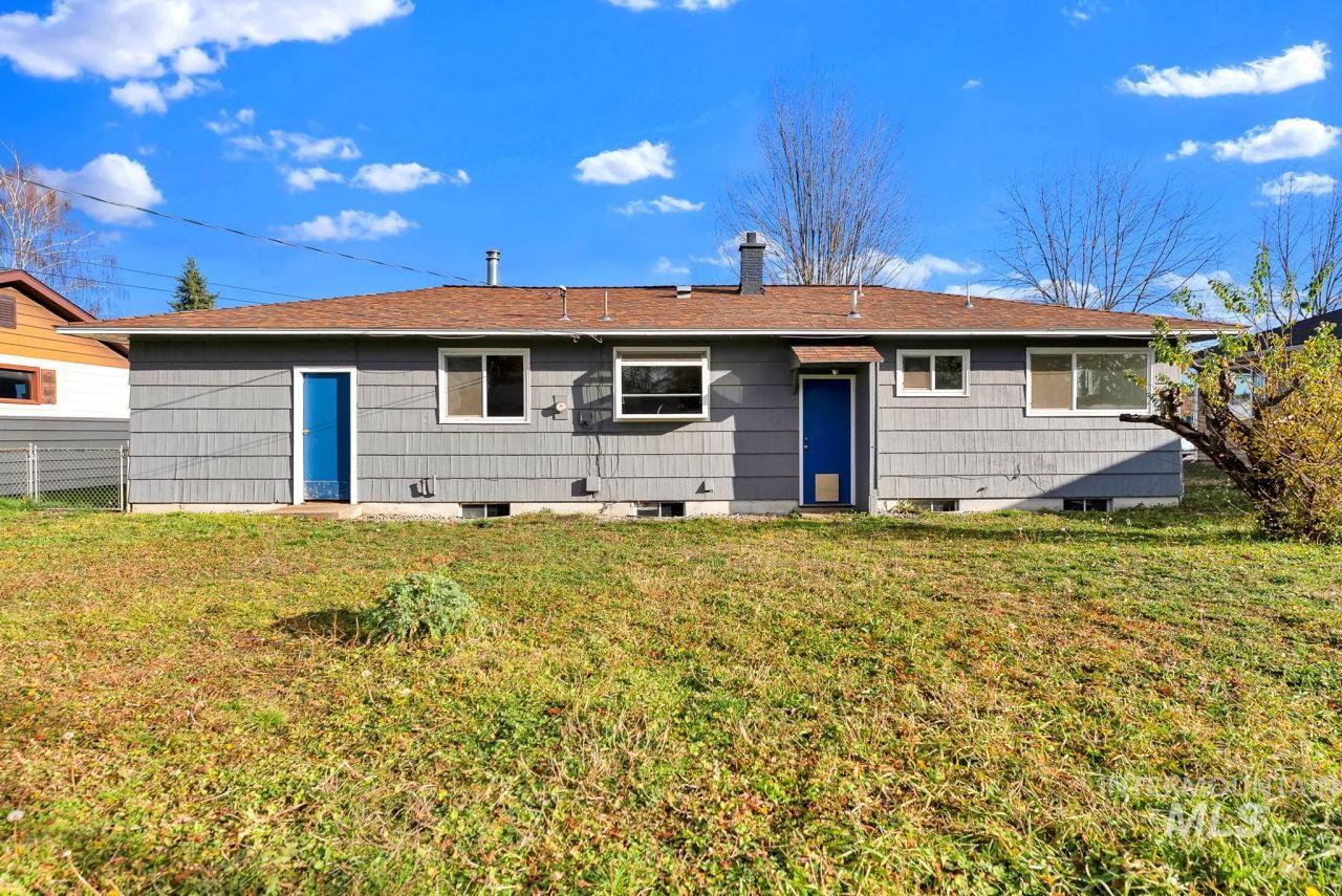 Rear view of house featuring a chimney and roof with shingles