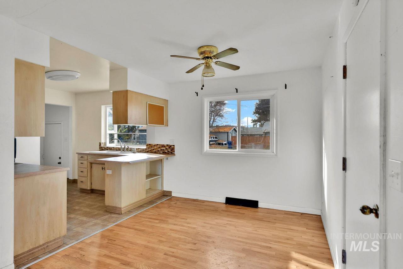 Kitchen with light wood-style floors, light brown cabinetry, light countertops, a peninsula, and a ceiling fan