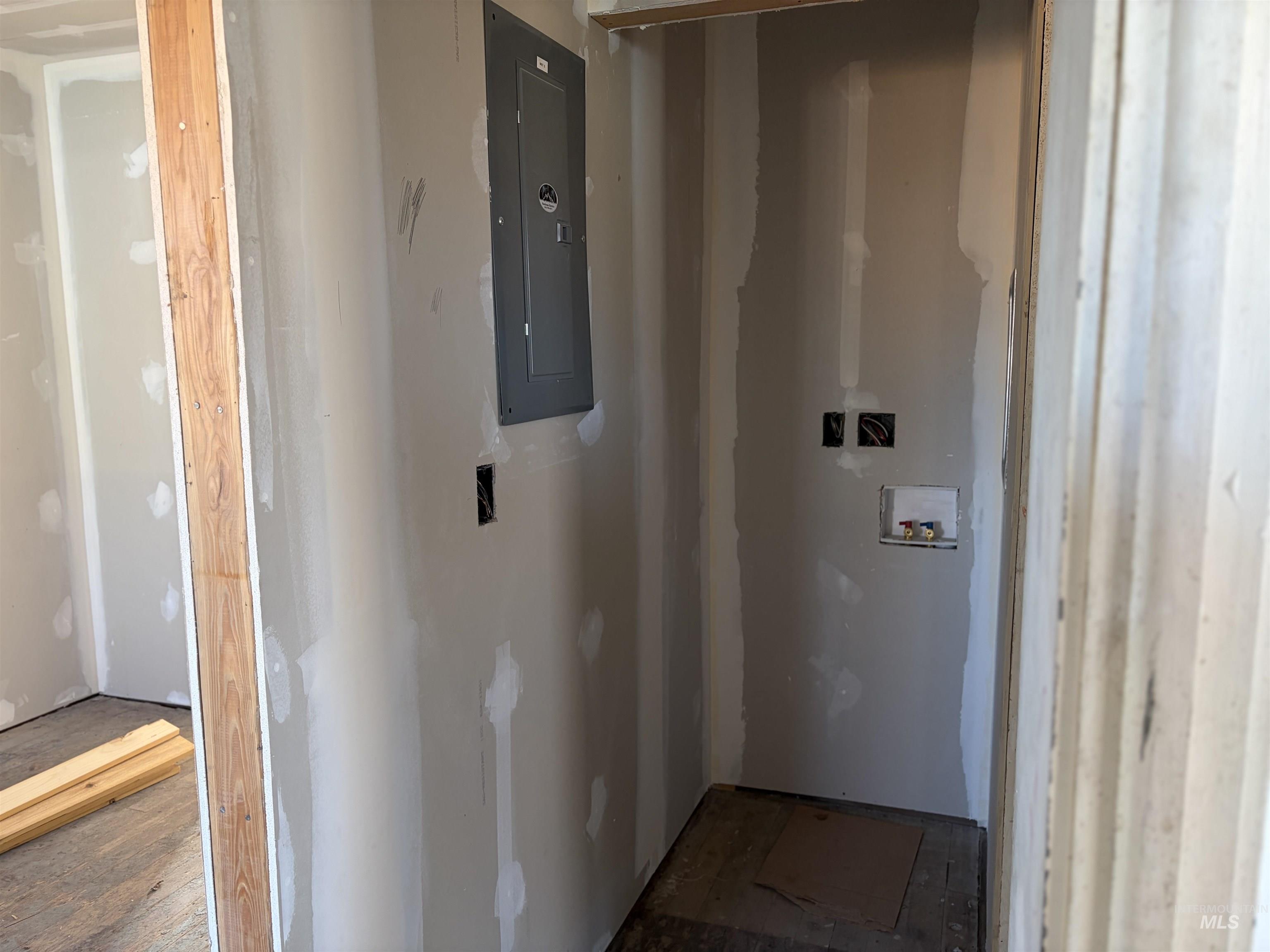 Laundry room featuring electric panel and hookup for a washing machine