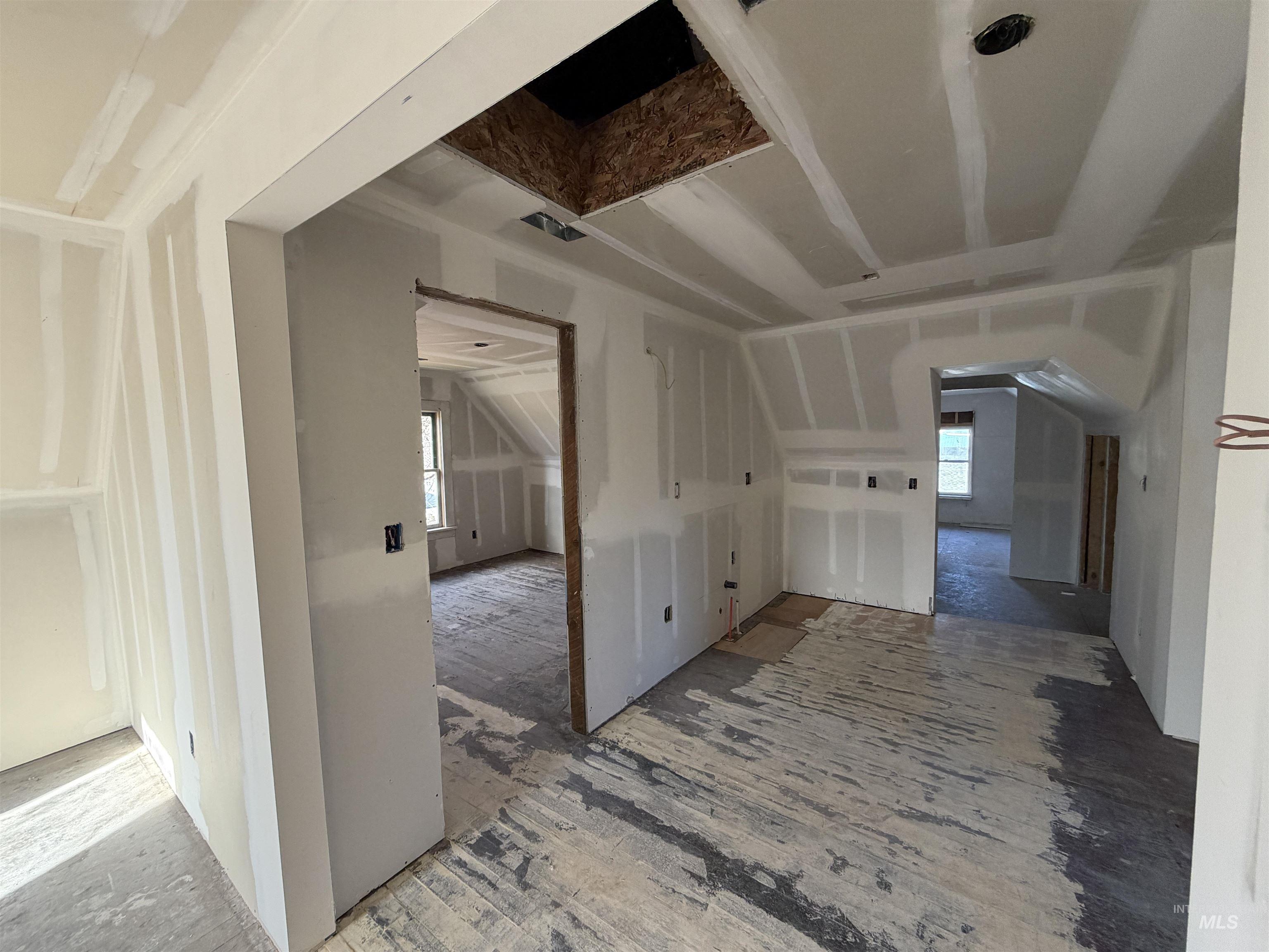 Additional living space featuring vaulted ceiling, plenty of natural light, and arched walkways