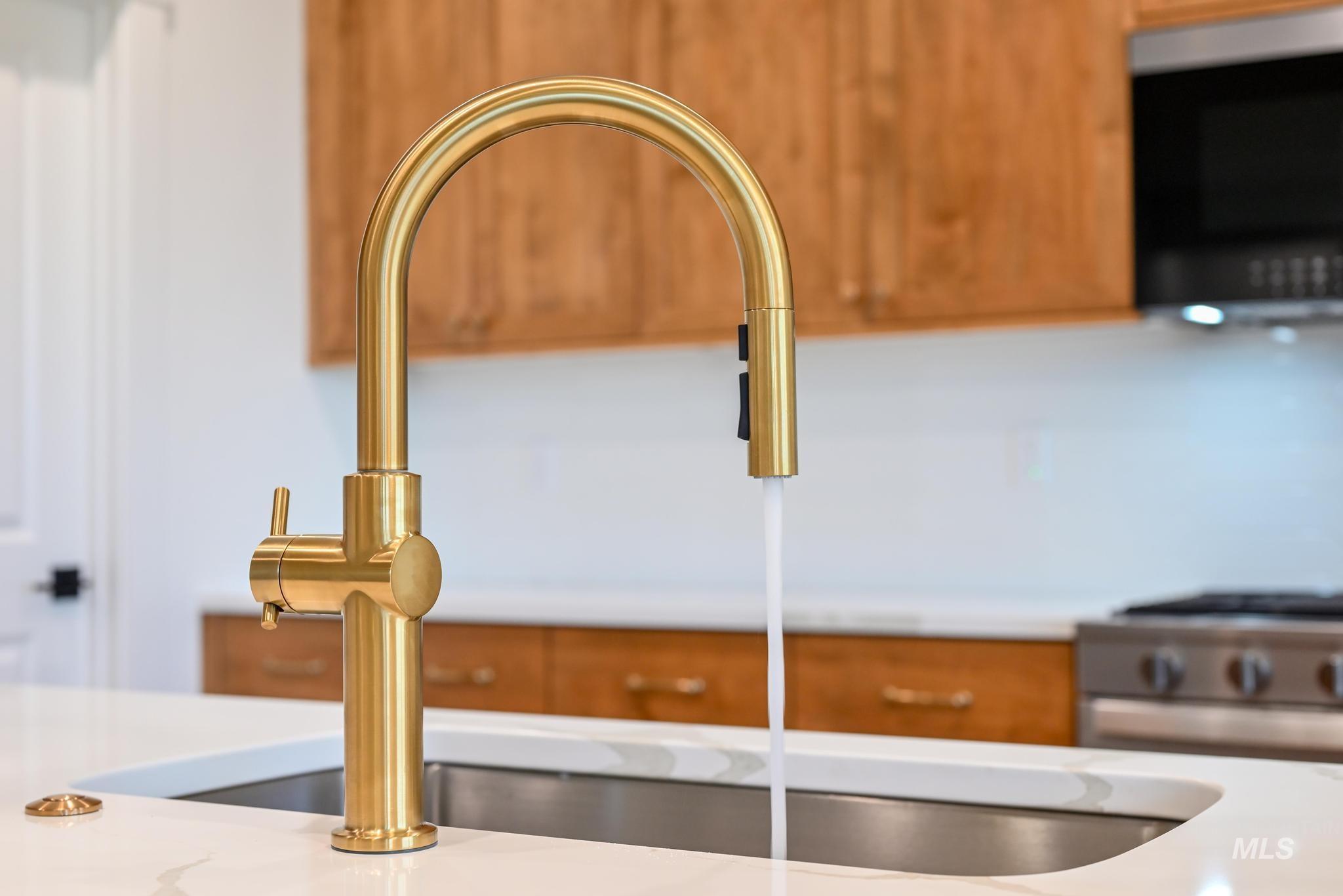 Kitchen view of appliances with stainless steel finishes, brown cabinets, and light stone counters