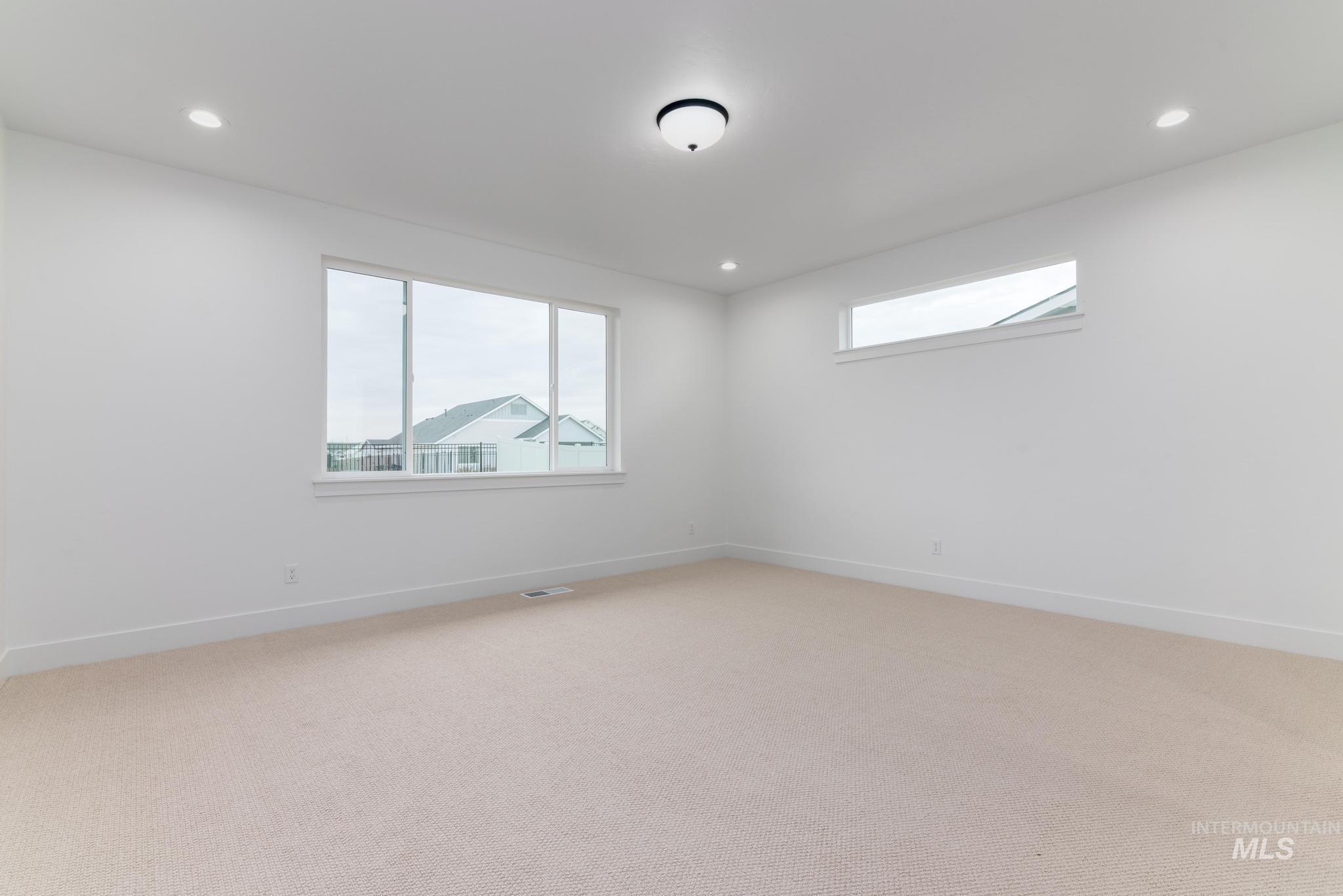 Unfurnished room featuring healthy amount of natural light, light carpet, and recessed lighting