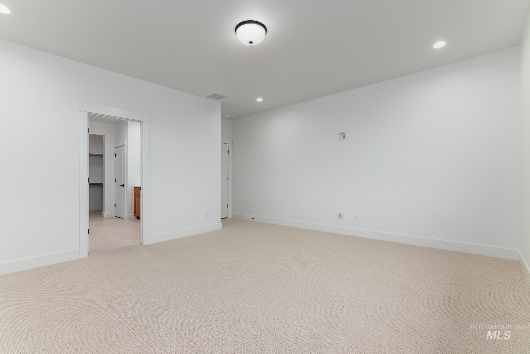 Empty room featuring recessed lighting and light carpet
