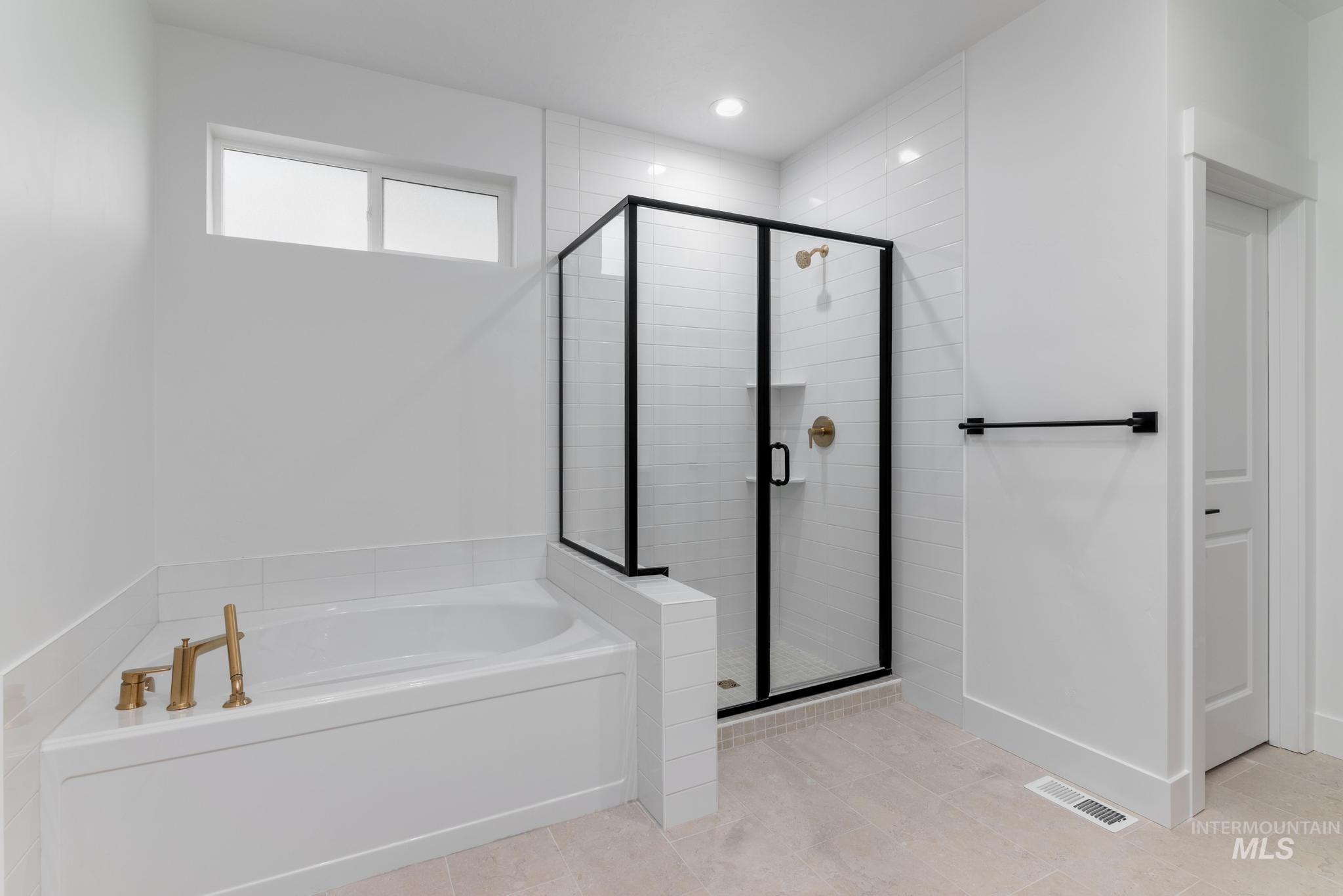 Full bath featuring a bath, a stall shower, and light tile patterned floors