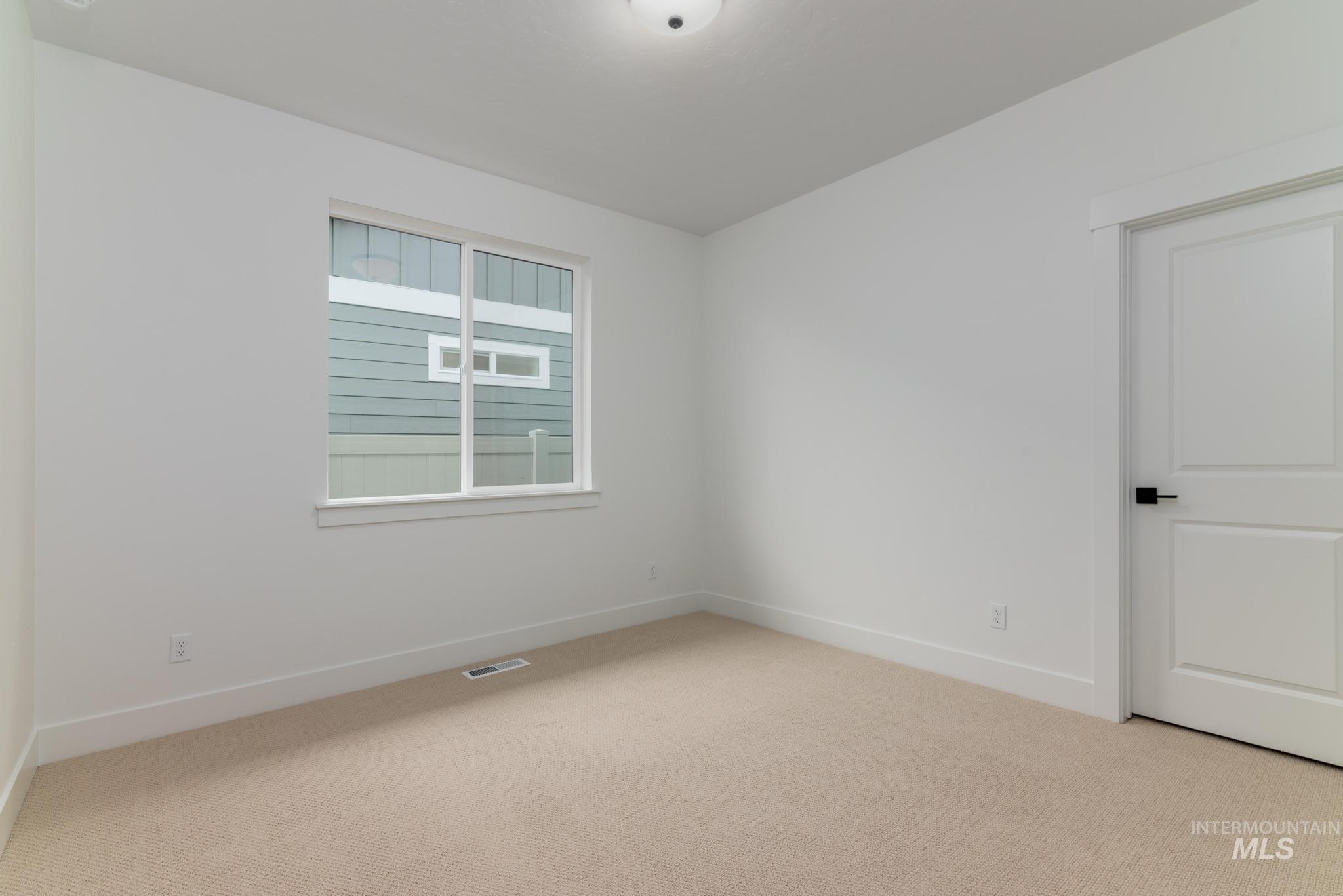 Empty room featuring carpet flooring and baseboards