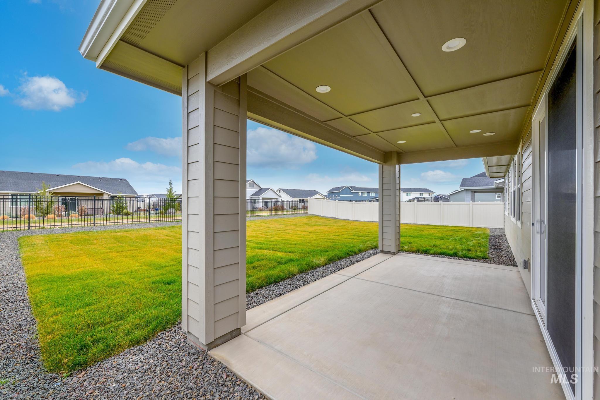 Fenced backyard with a patio area and a residential view