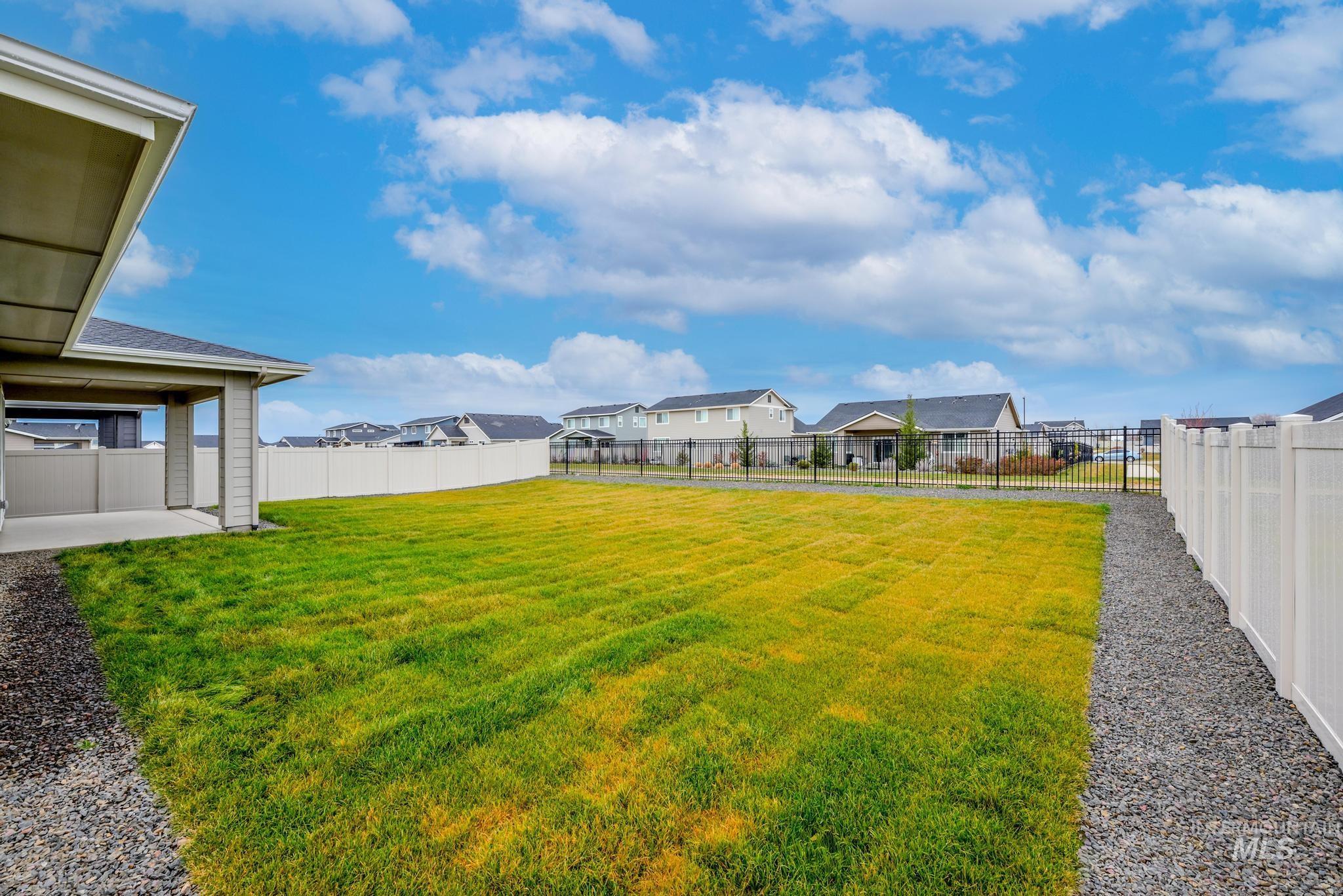 Fenced backyard with a residential view and a patio area