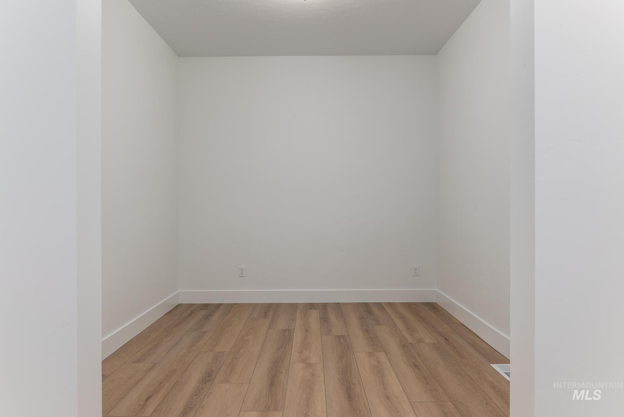 Unfurnished room featuring light wood finished floors and baseboards