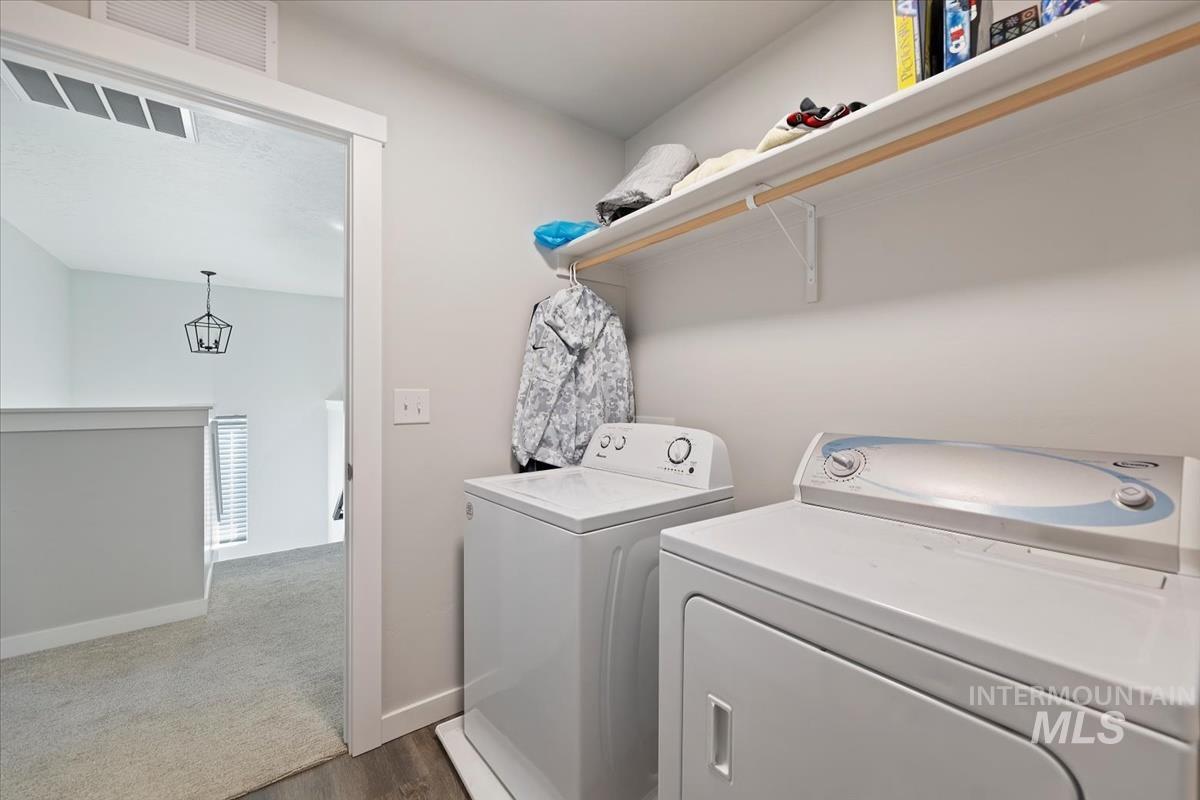 Washroom with independent washer and dryer and dark wood-style floors