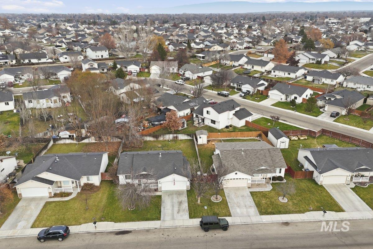 Aerial view of property and surrounding area with nearby suburban area
