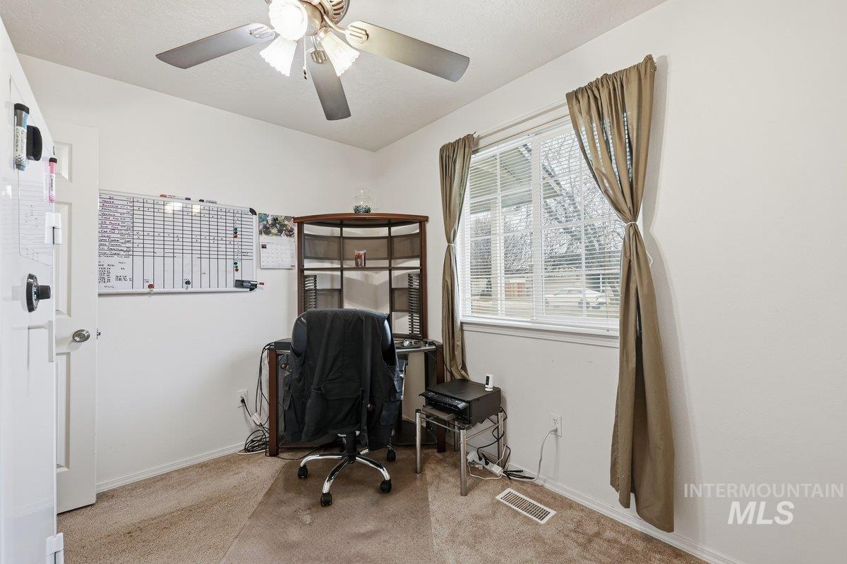 Office area featuring light carpet and baseboards