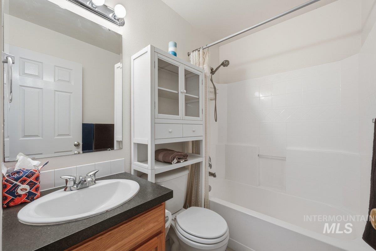 Full bath featuring shower / bathtub combination with curtain and vanity