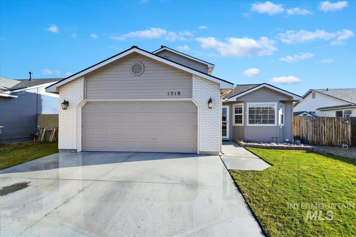 Ranch-style house featuring brick siding, driveway, and a garage