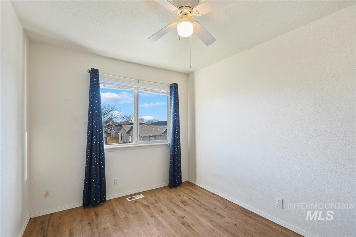 Unfurnished room with wood finished floors and ceiling fan