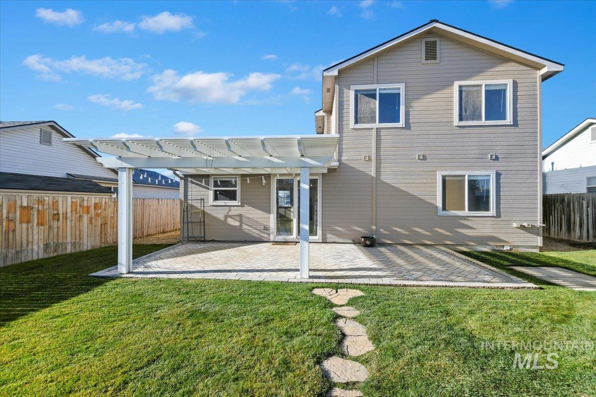 Rear view of house featuring a pergola, a patio area, and a fenced backyard