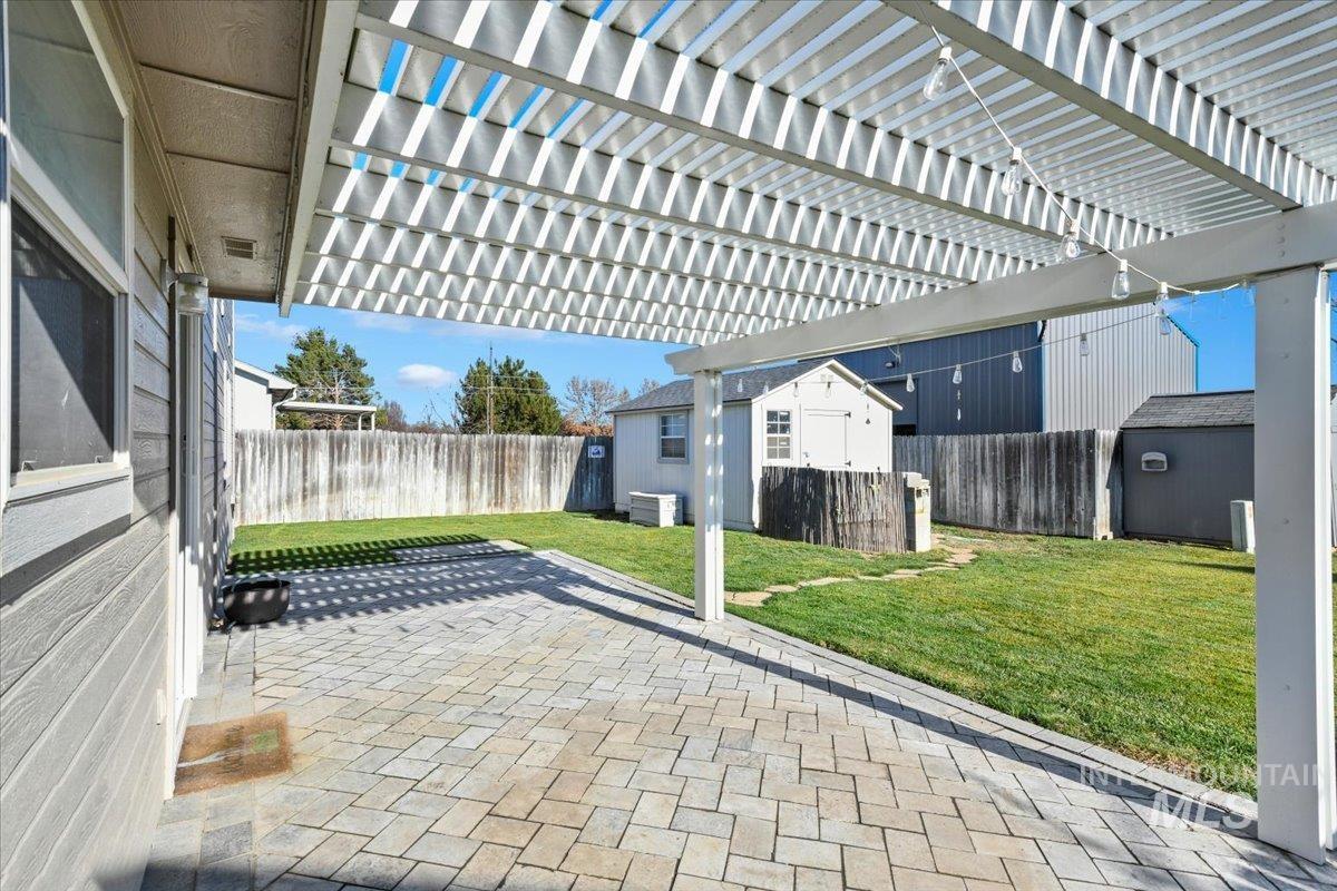 Fenced backyard with a storage shed, a patio, and a pergola