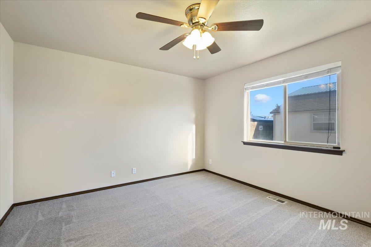 Spare room featuring carpet flooring and ceiling fan
