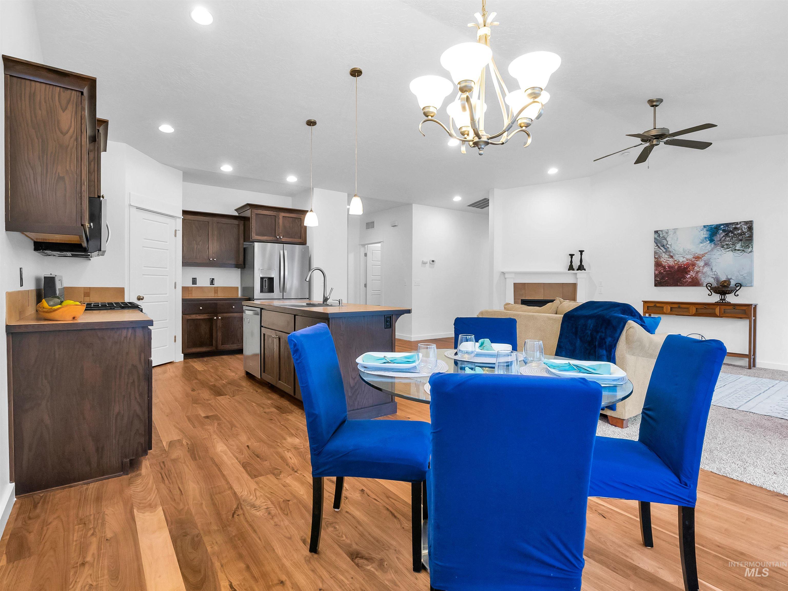 Dining space with a chandelier, light wood-style flooring, recessed lighting, and ceiling fan