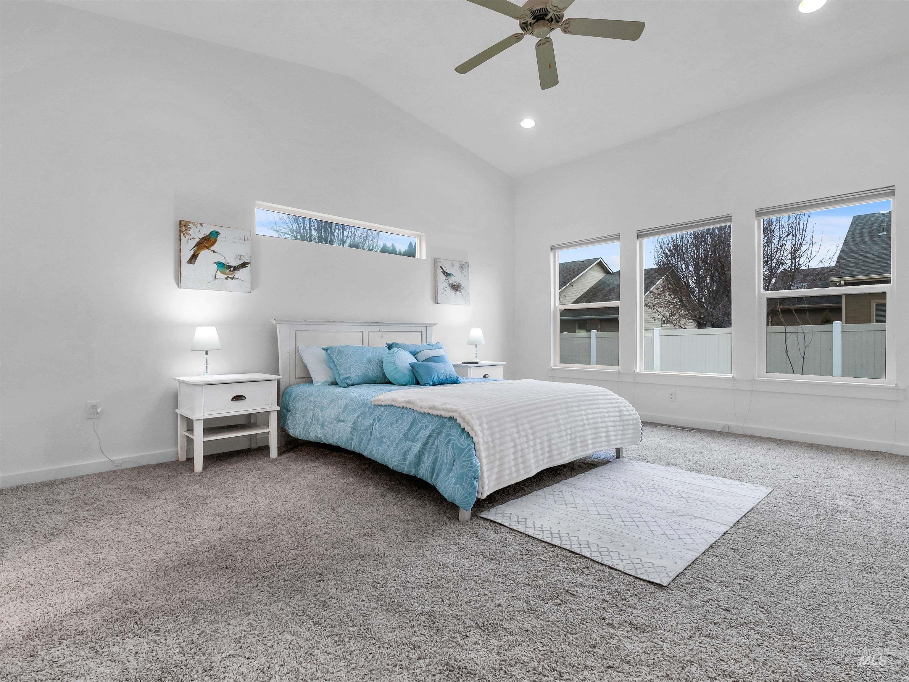 Carpeted bedroom with lofted ceiling, ceiling fan, and recessed lighting