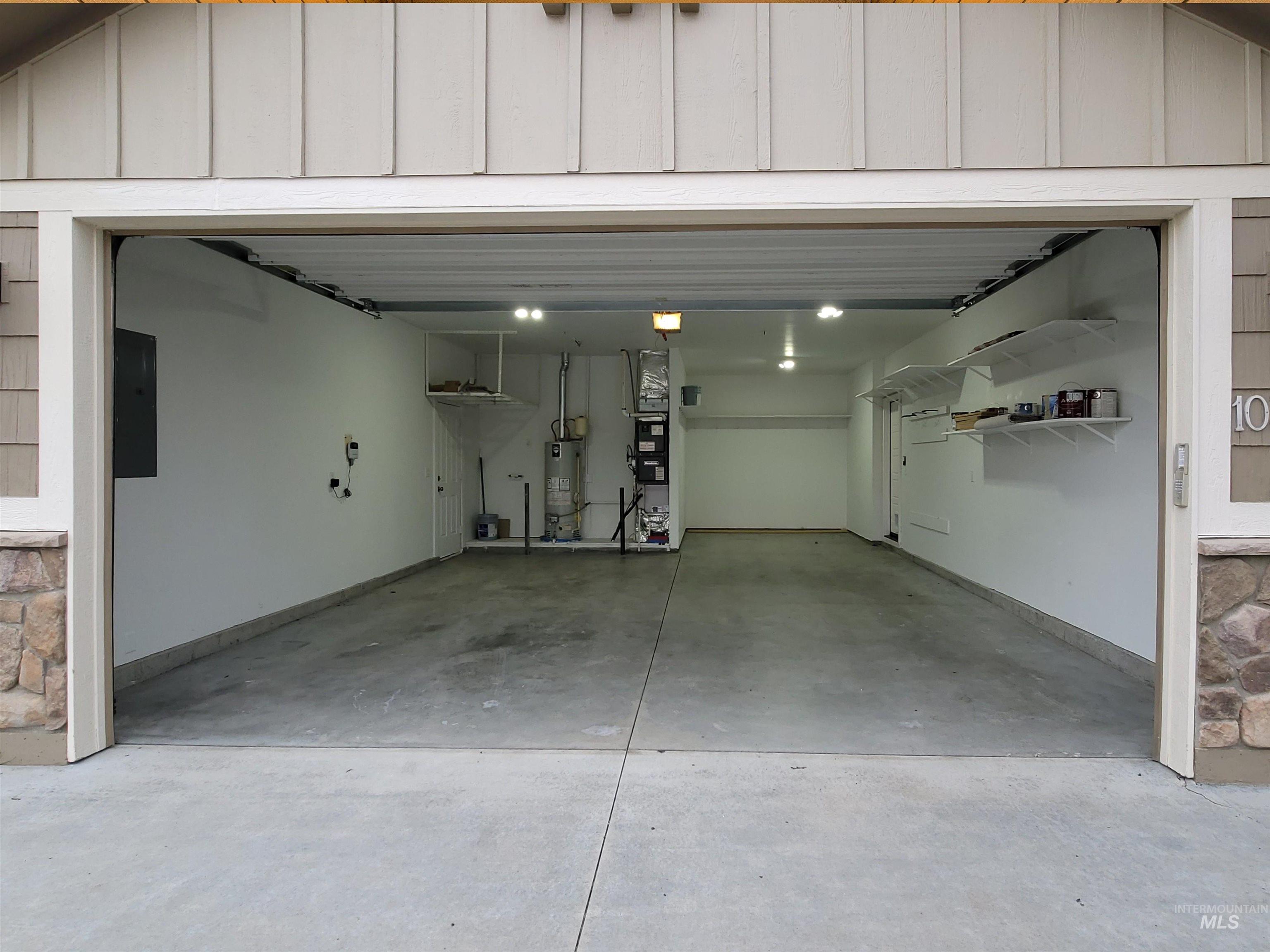 Garage featuring gas water heater and electric panel