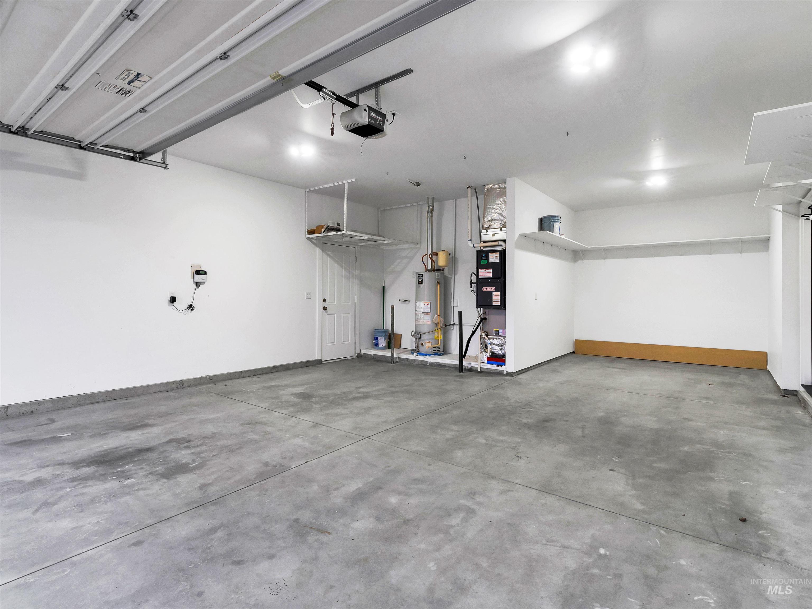 Garage featuring gas water heater and a garage door opener