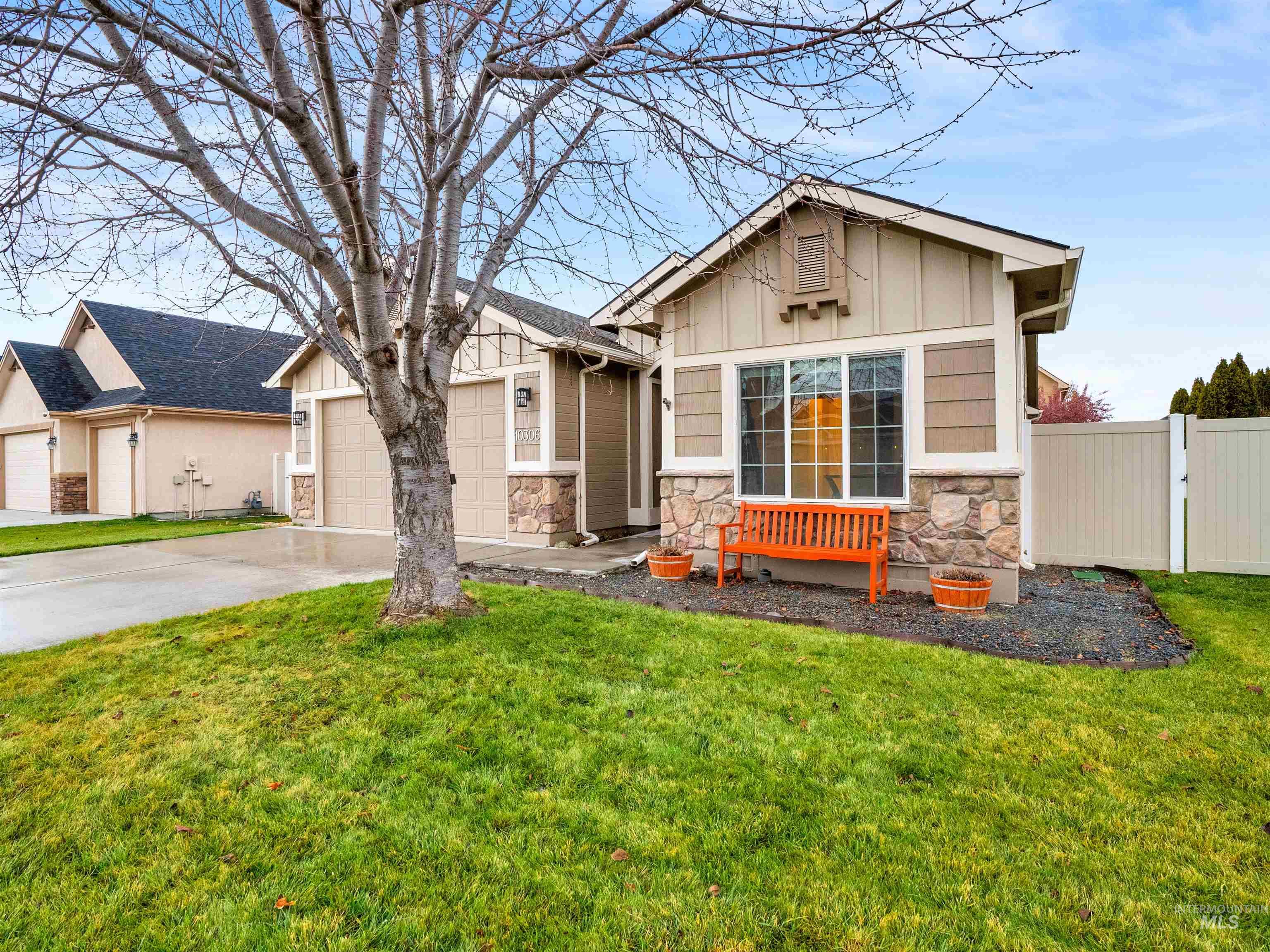 Craftsman-style house with stone siding, board and batten siding, driveway, and an attached garage