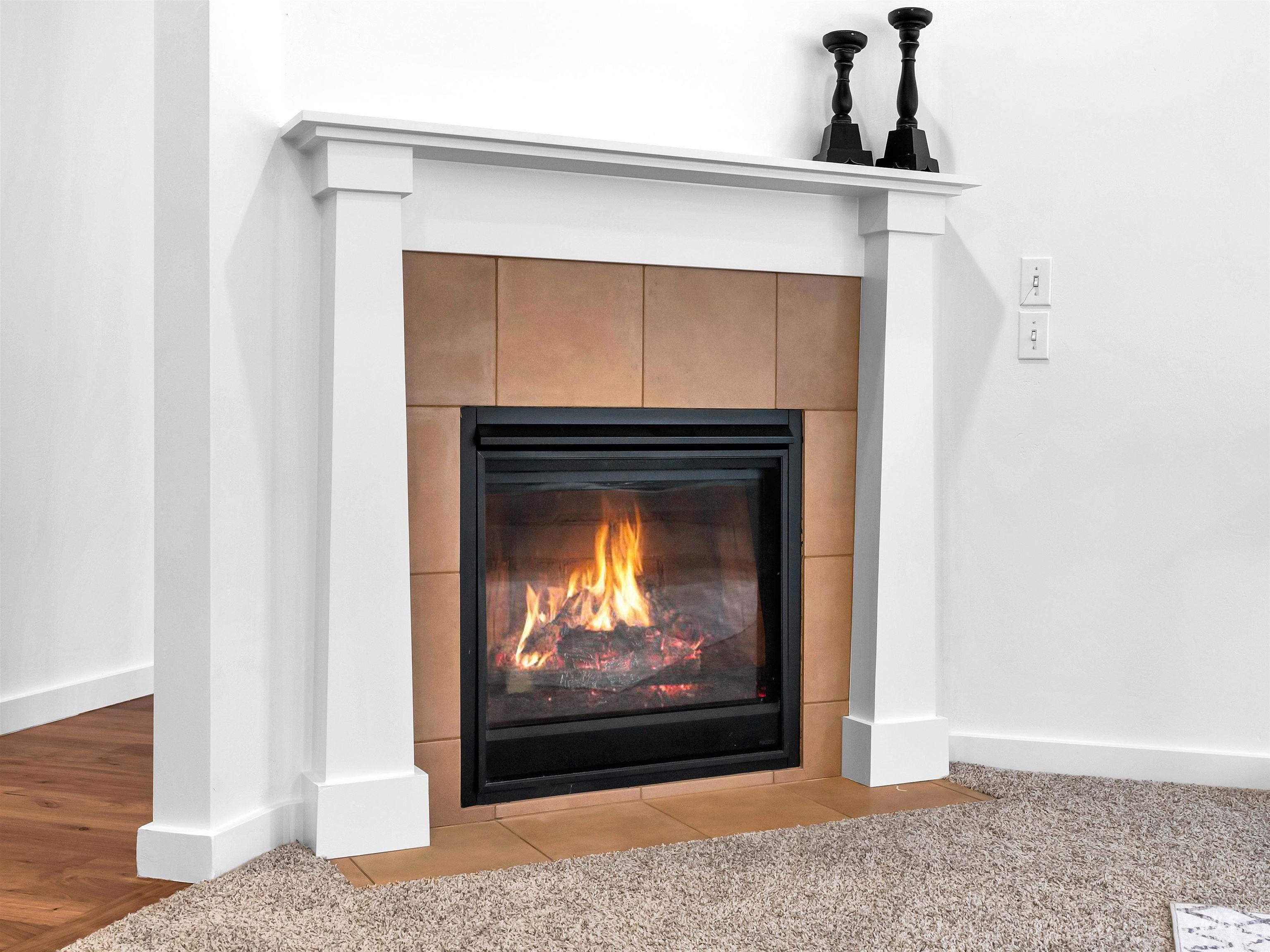Detailed view of a tile fireplace and carpet flooring