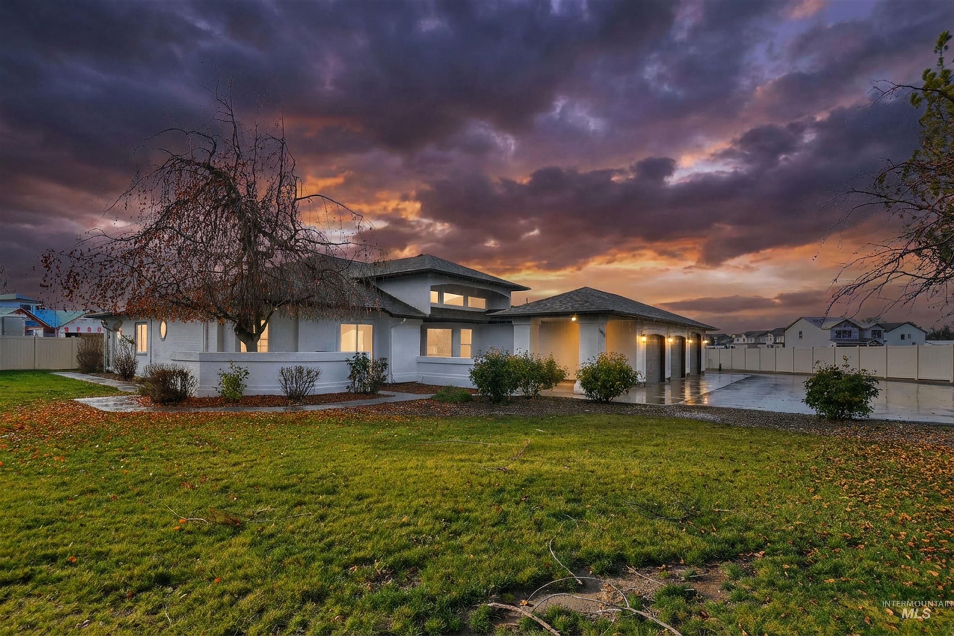 View of front of property featuring driveway, an attached garage, and stucco siding