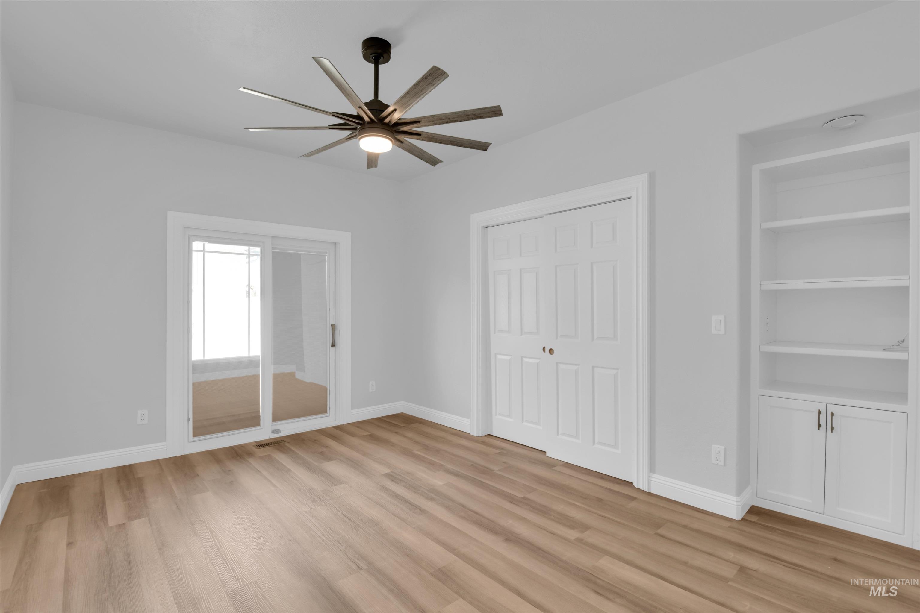 Unfurnished bedroom featuring light wood-style flooring, a ceiling fan, and a closet