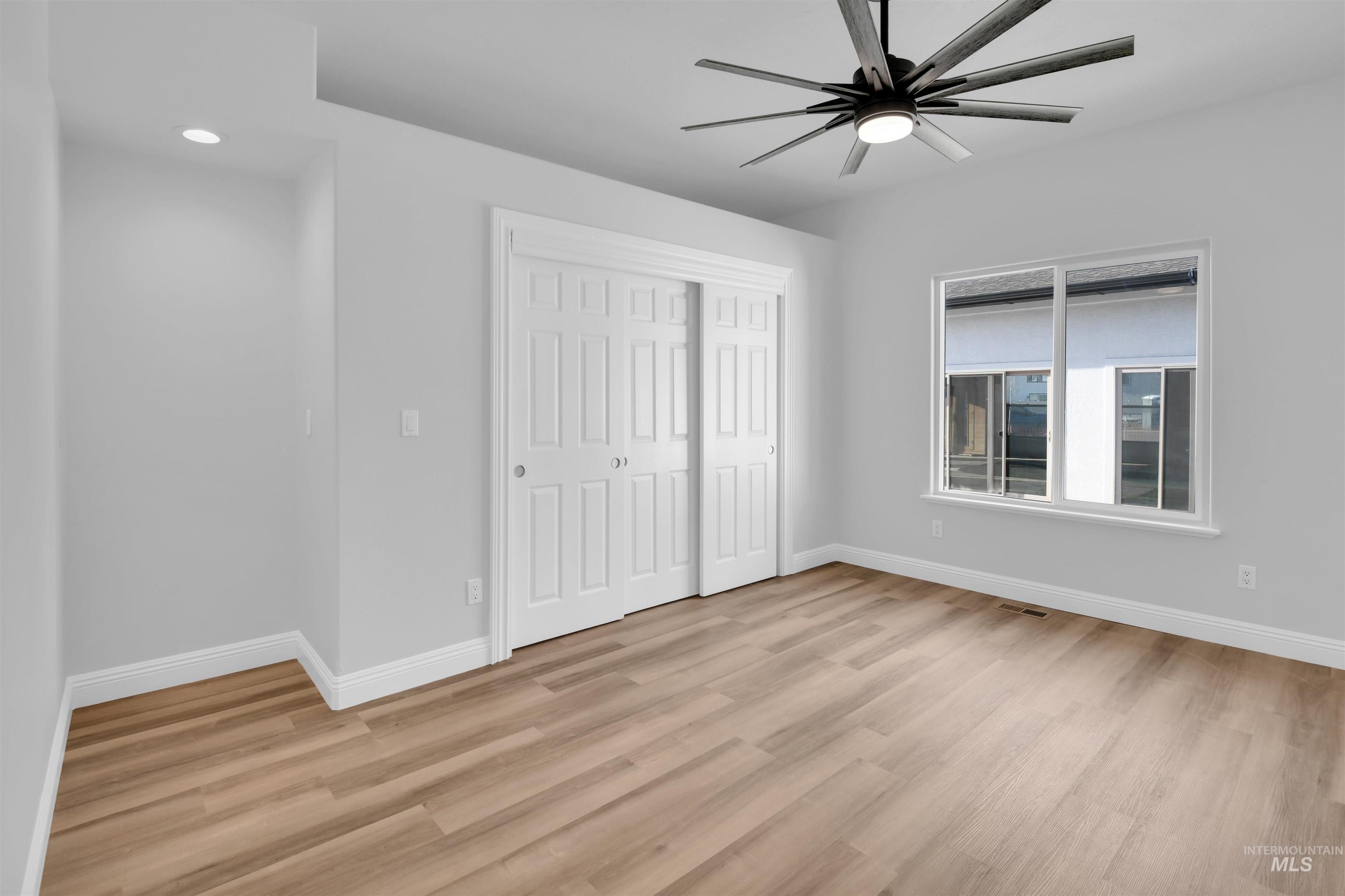 Unfurnished bedroom featuring a closet, a ceiling fan, light wood-type flooring, and recessed lighting
