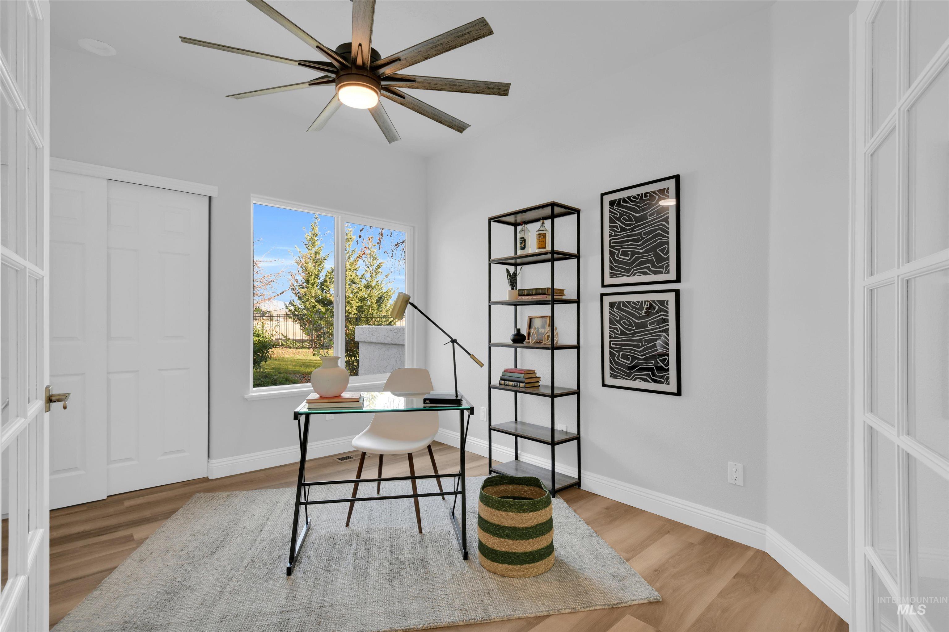 Office with light wood finished floors and ceiling fan