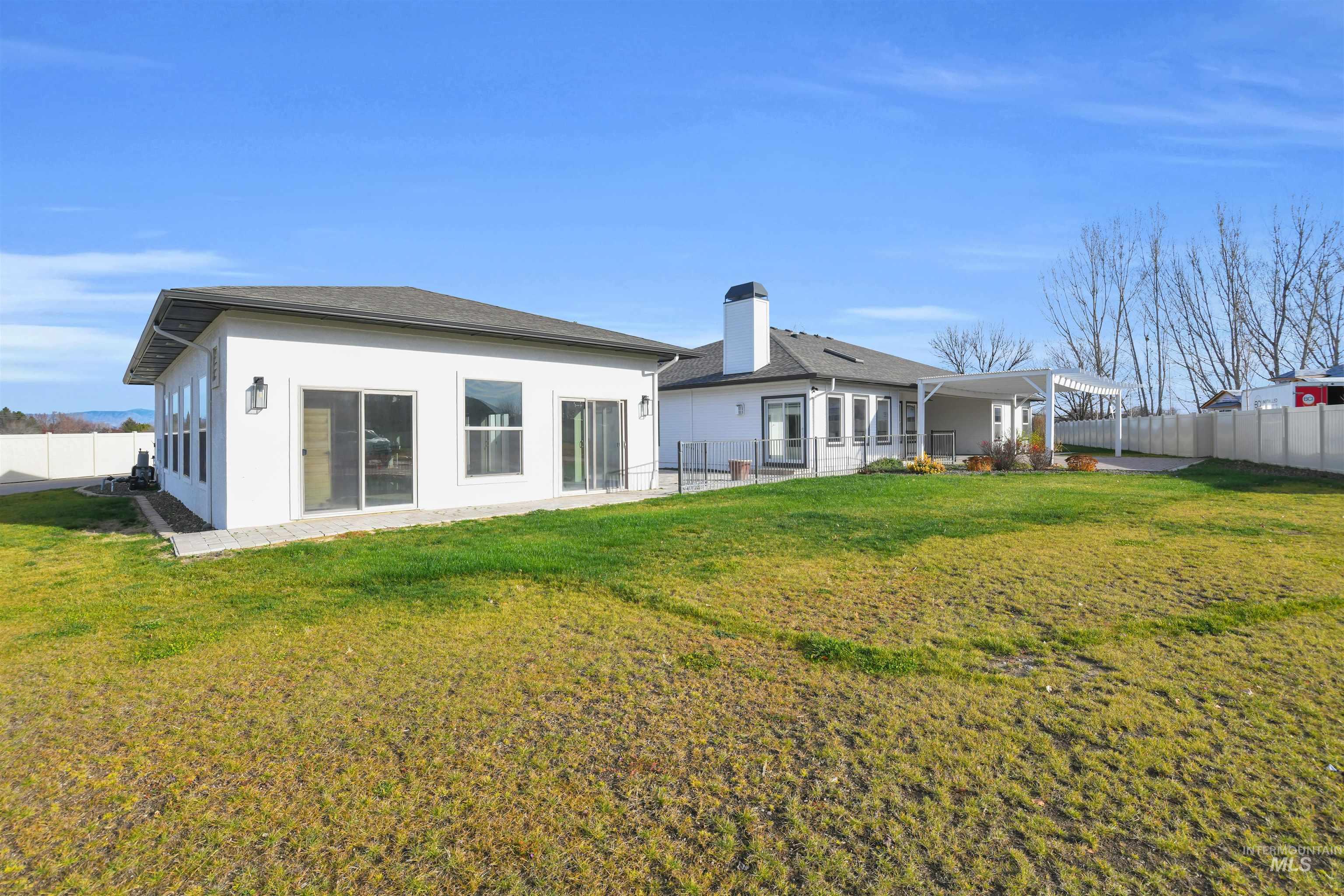 Back of property with a fenced backyard, a patio, and stucco siding