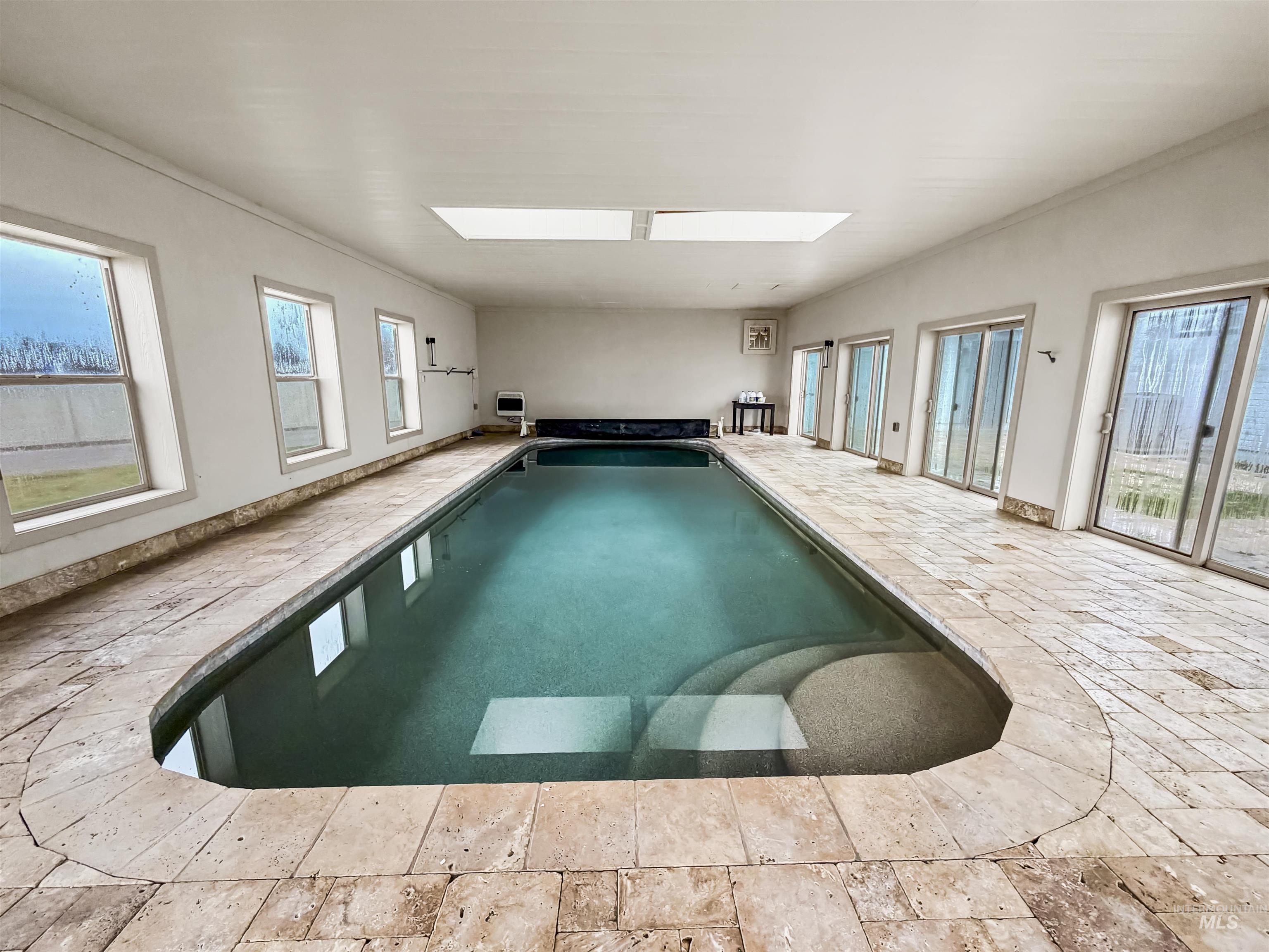 Indoor pool featuring a skylight