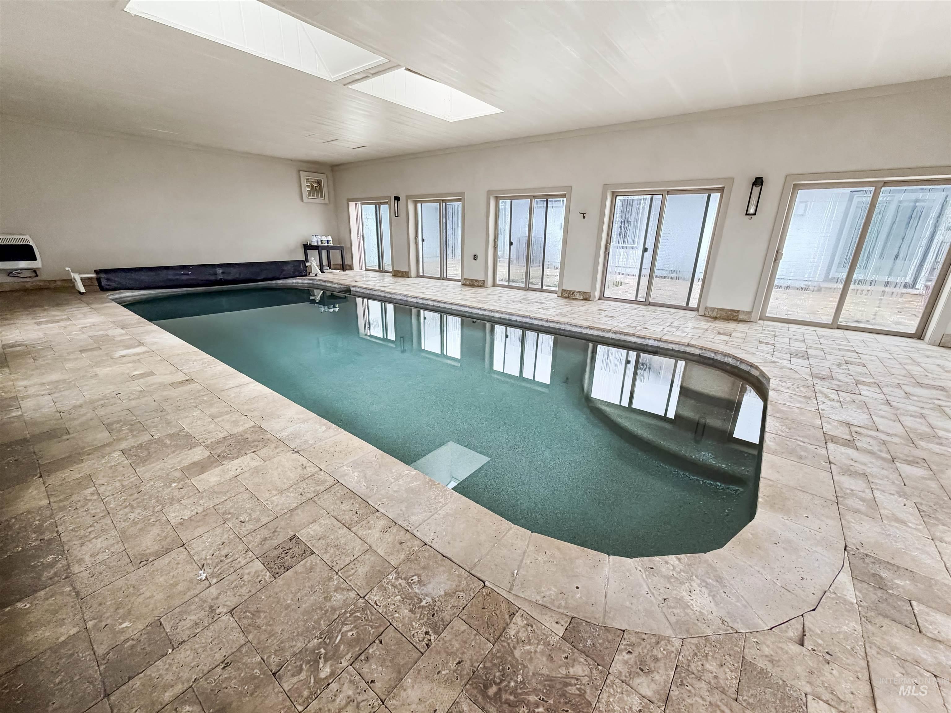 Indoor pool featuring a skylight