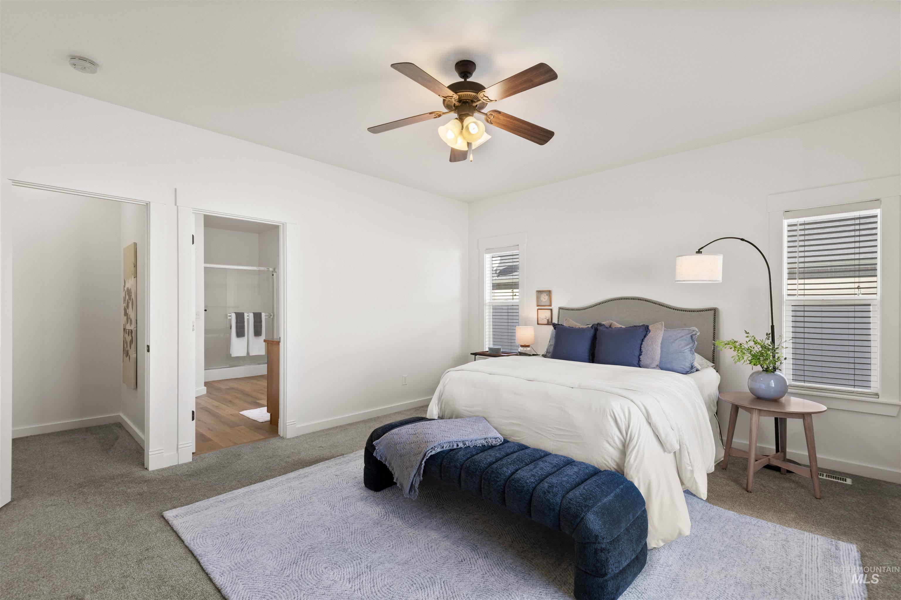 Carpeted bedroom featuring a ceiling fan and connected bathroom