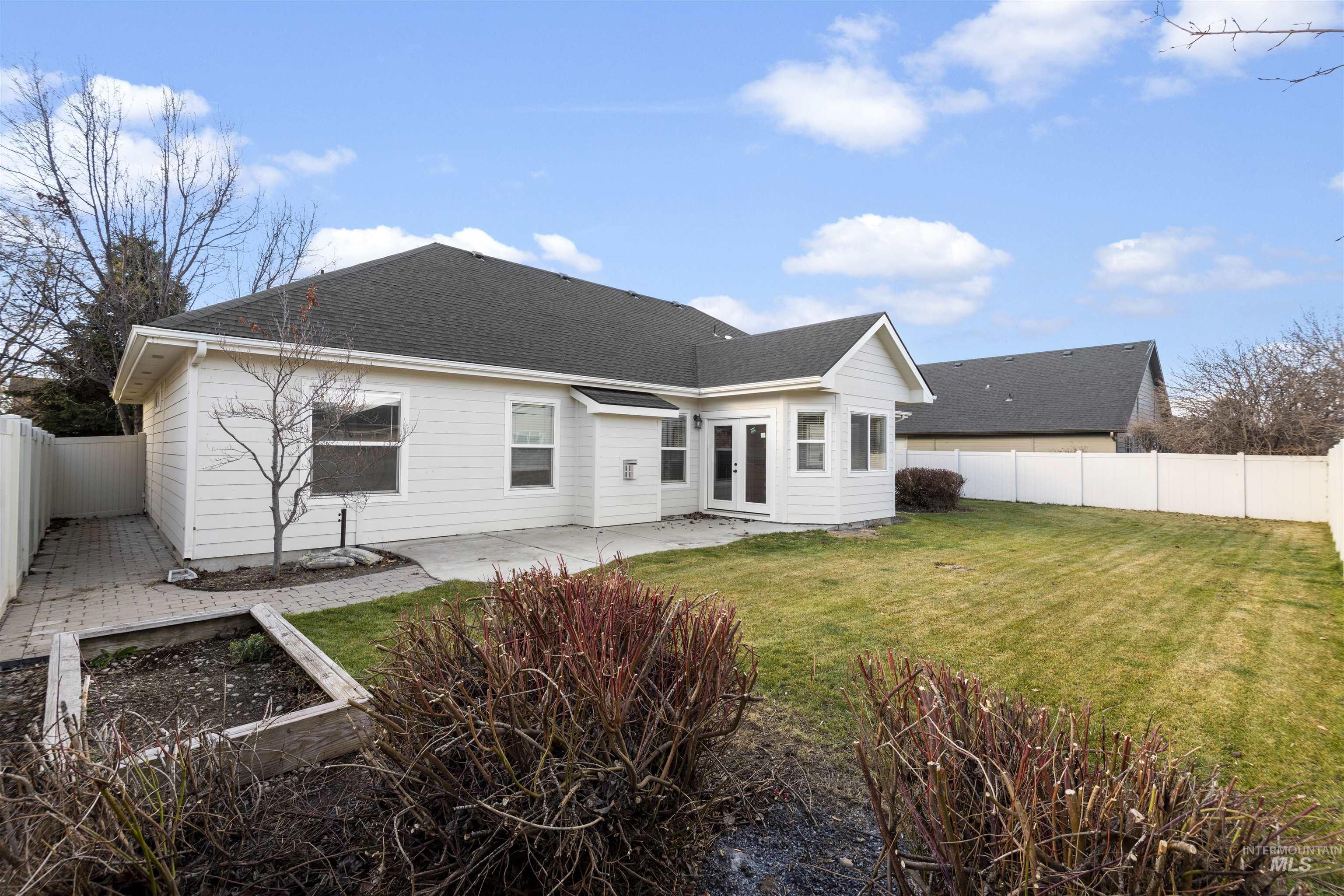 Back of house featuring a fenced backyard, a shingled roof, a patio, and french doors