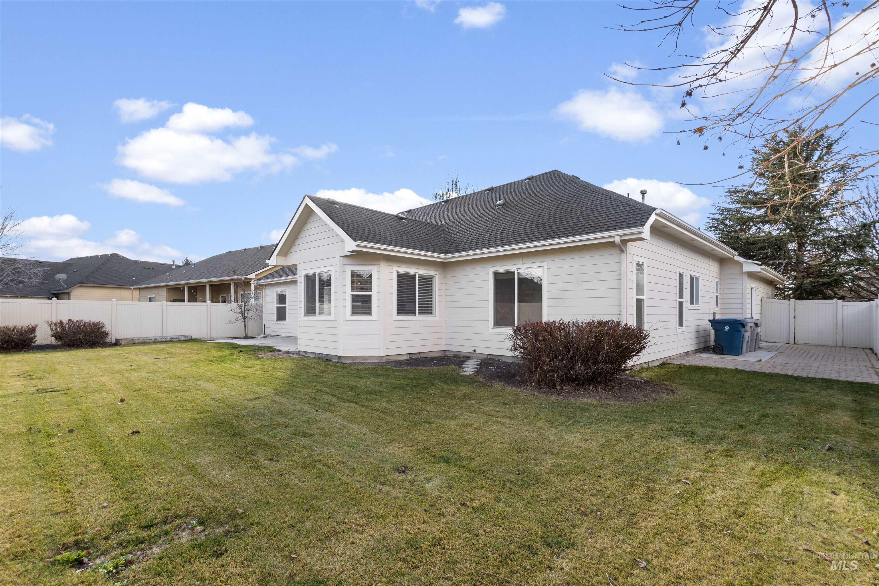 Rear view of property with a fenced backyard, a patio area, and roof with shingles