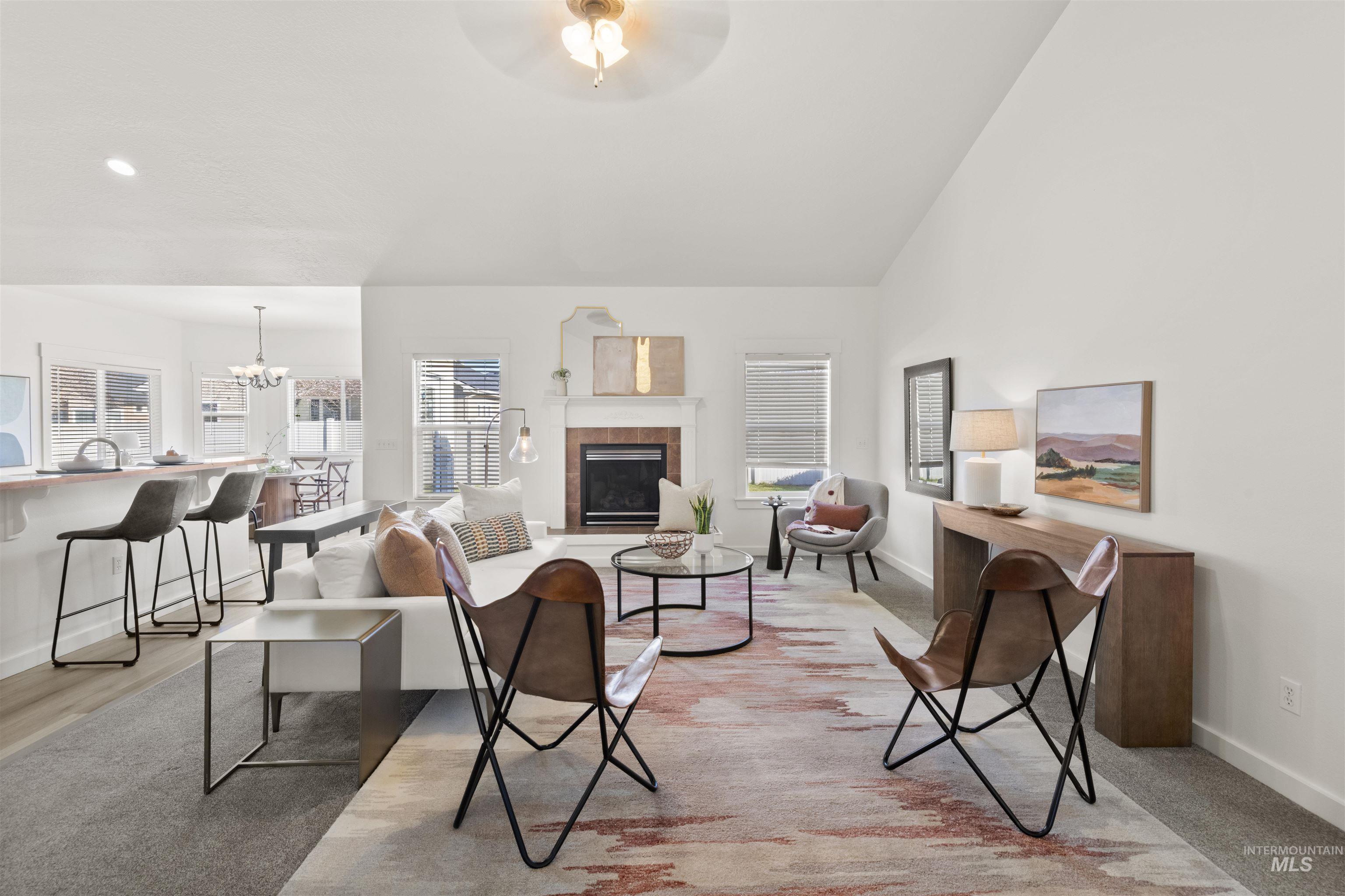 Living area featuring a fireplace, a chandelier, and lofted ceiling