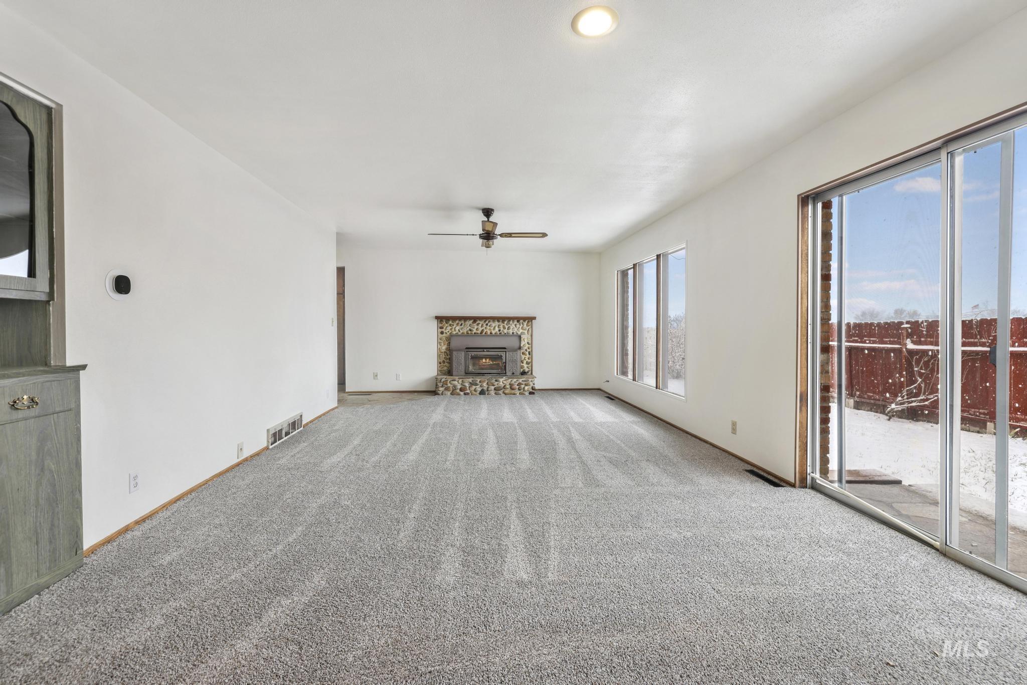 Unfurnished living room featuring a glass covered fireplace, carpet flooring, ceiling fan, and recessed lighting