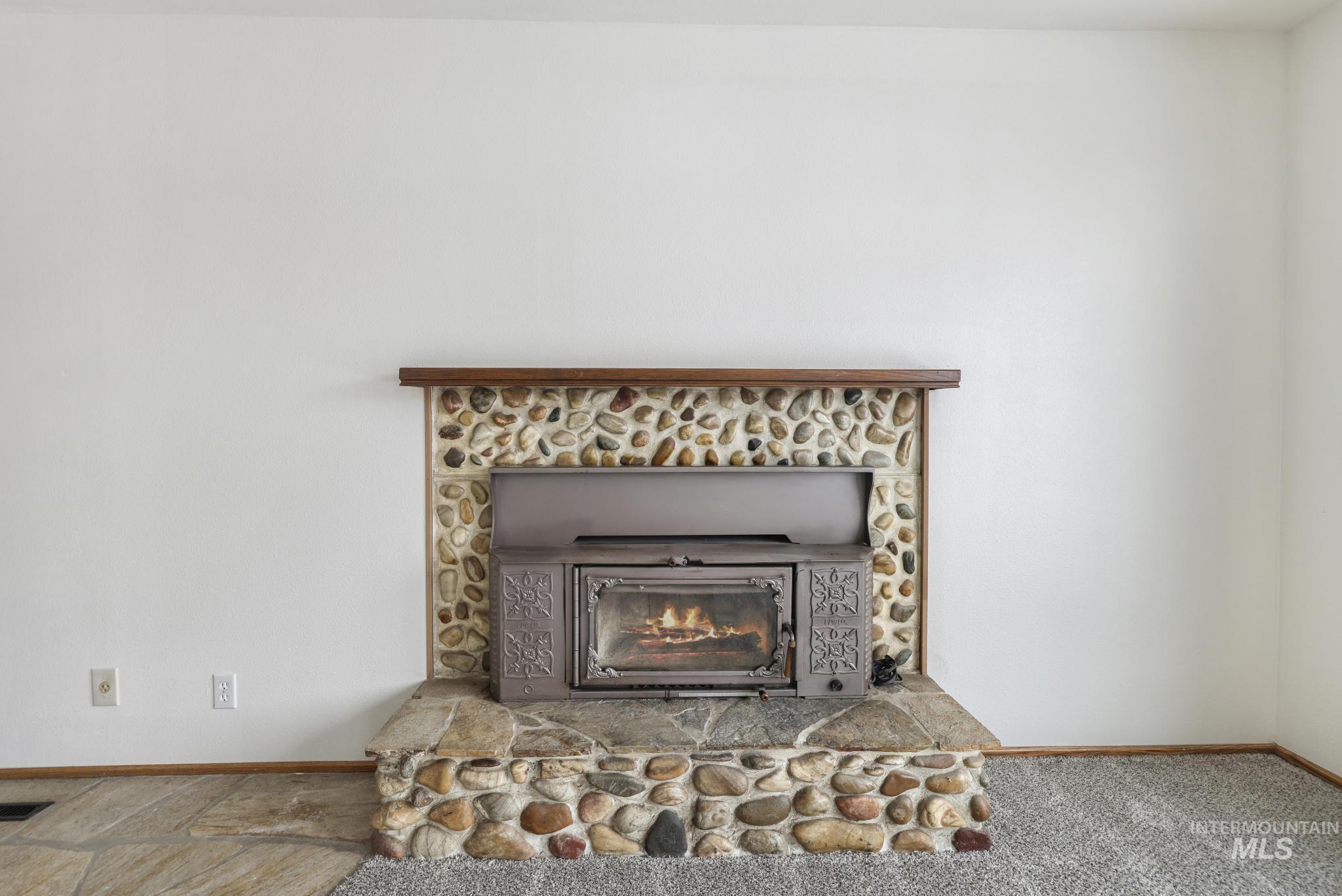 Detailed view of baseboards and a stone fireplace