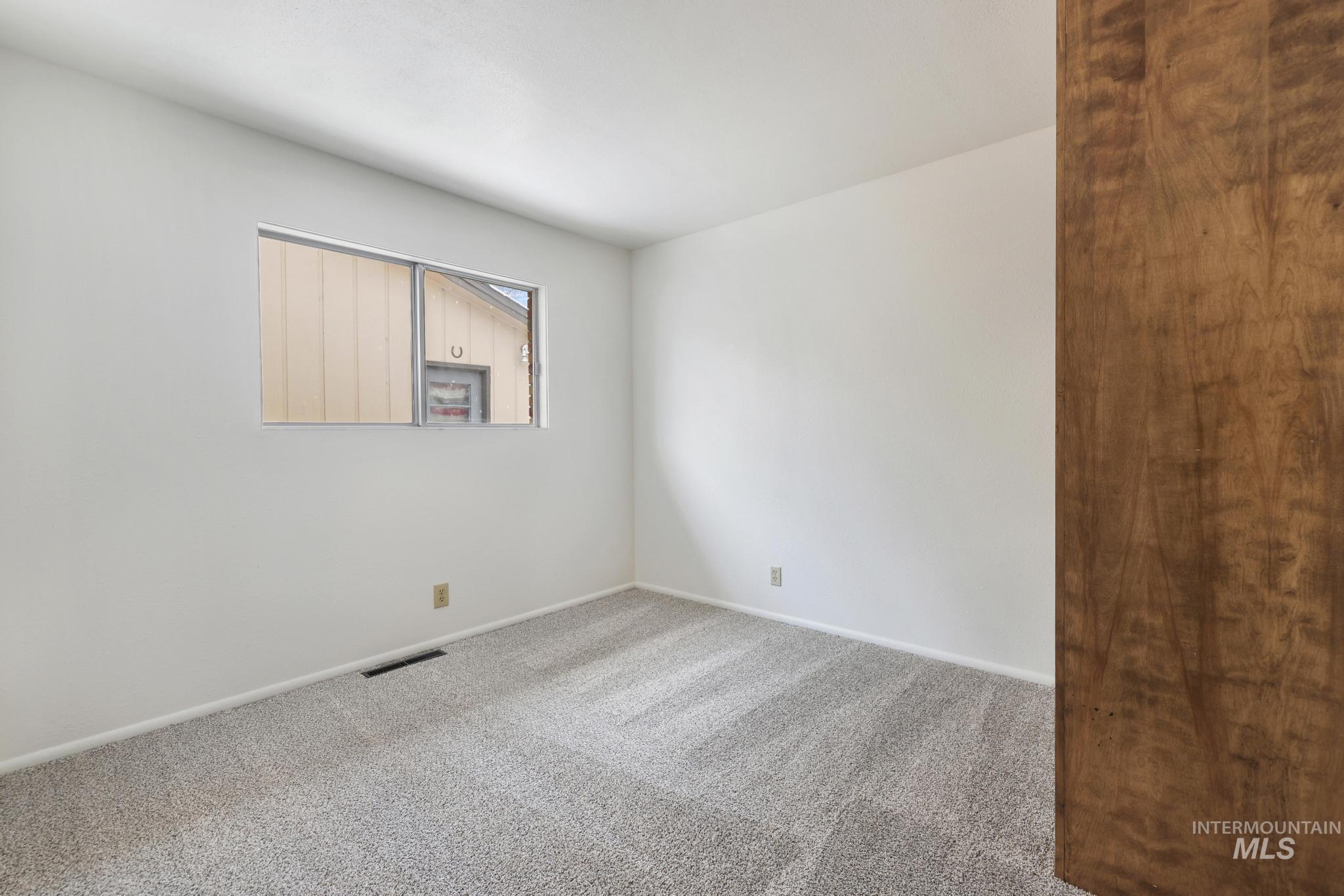 Carpeted empty room featuring baseboards
