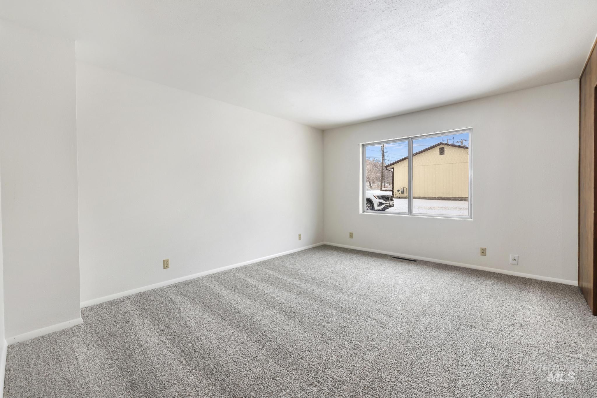 Carpeted empty room featuring baseboards