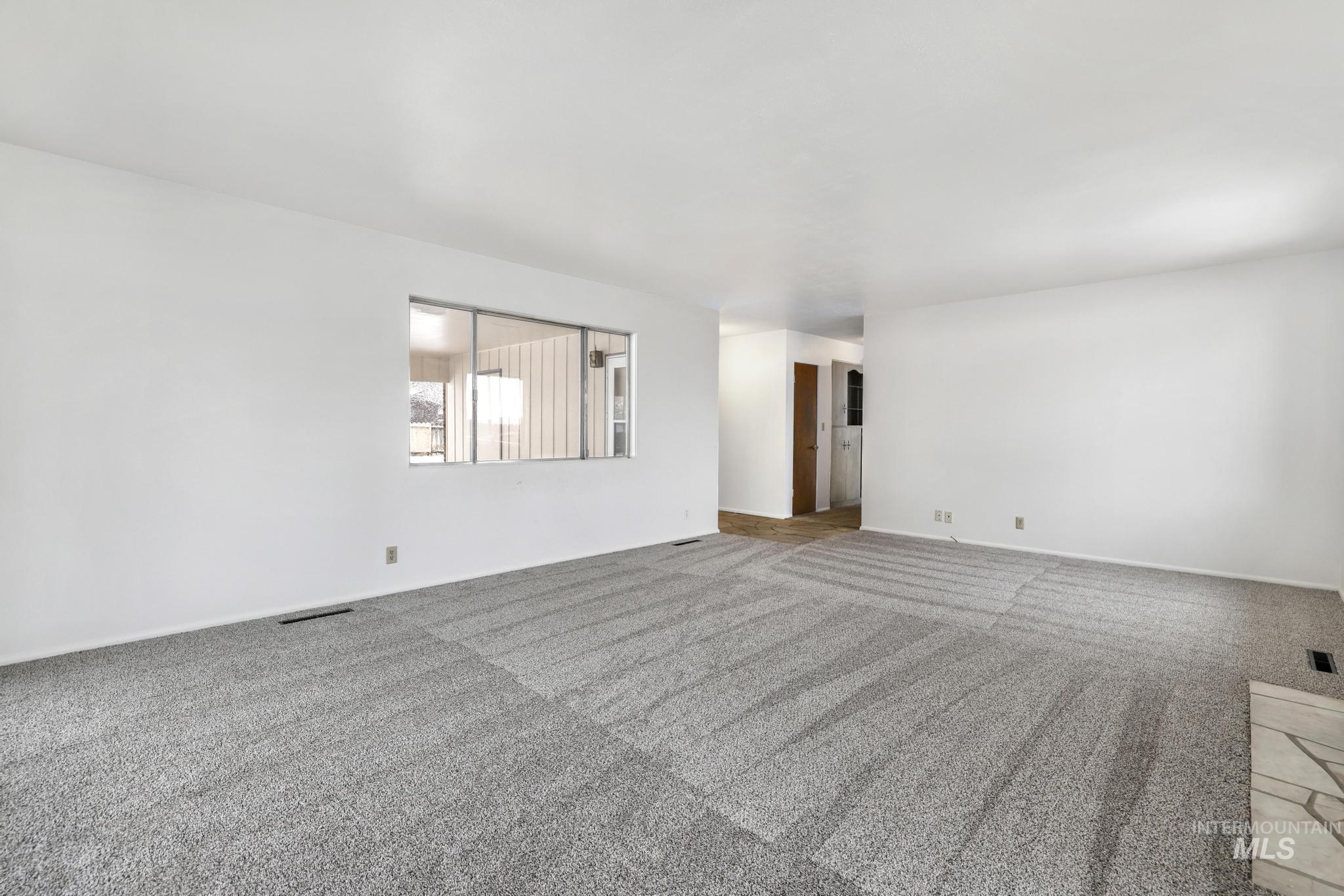 Carpeted spare room with baseboards