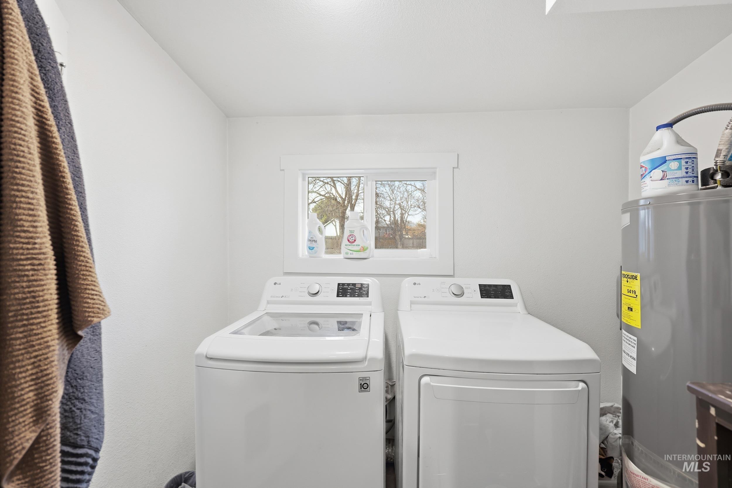 Laundry room with electric water heater and washing machine and dryer