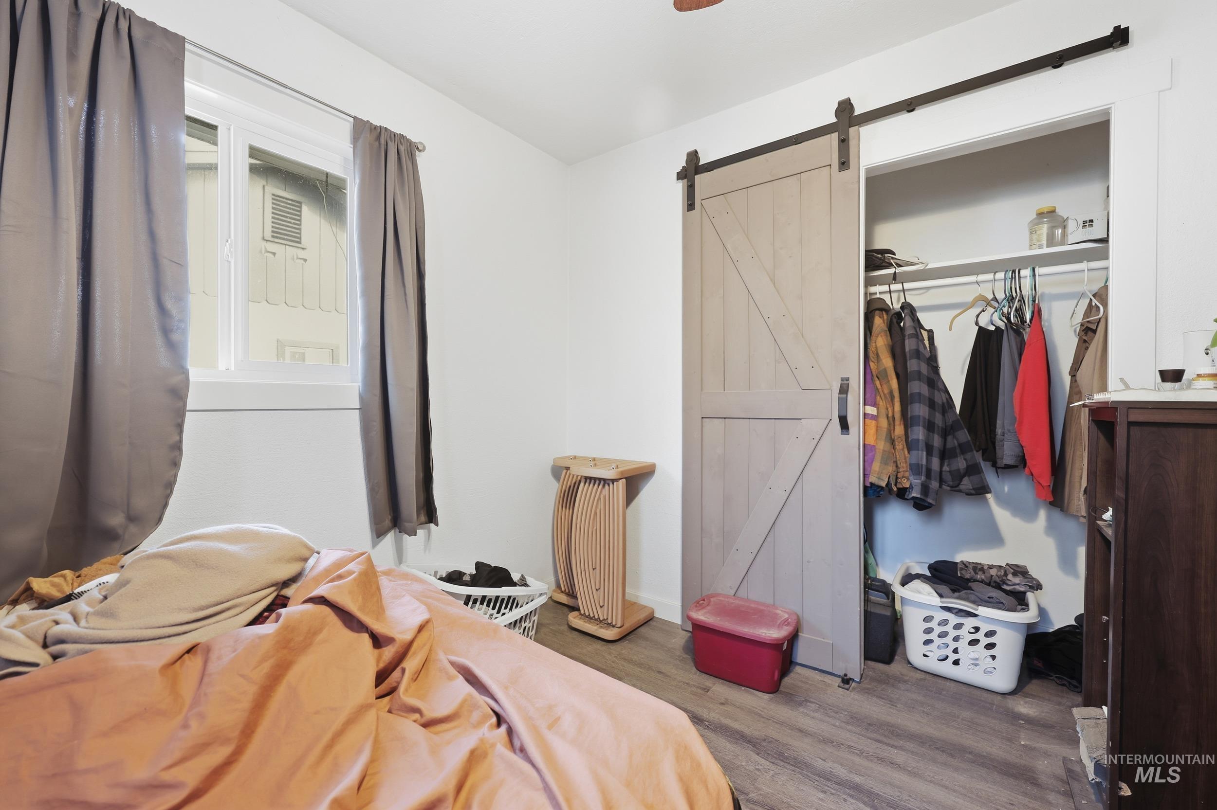 Bedroom featuring a closet, wood finished floors, and a barn door