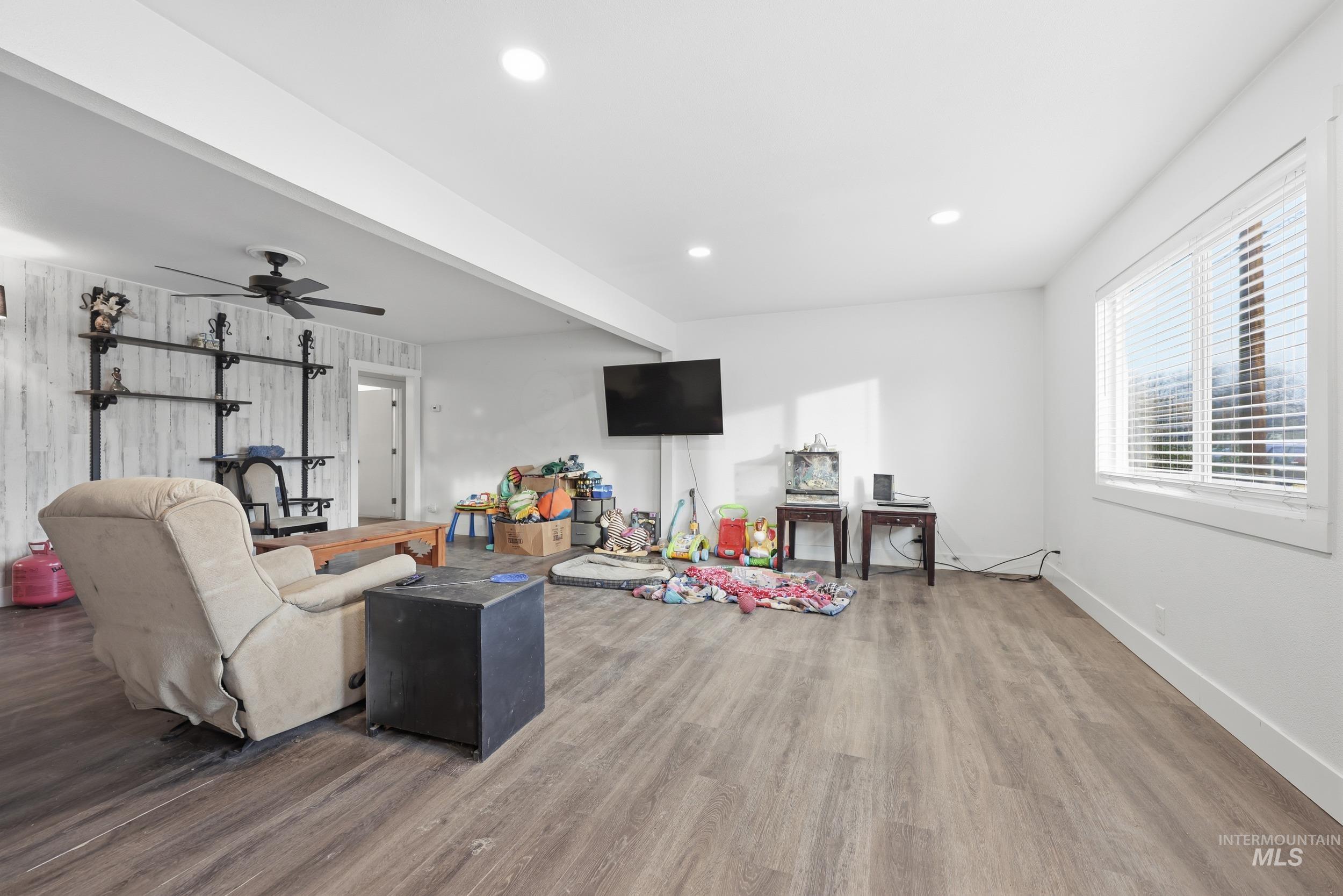 Living area featuring ceiling fan, wood finished floors, and recessed lighting
