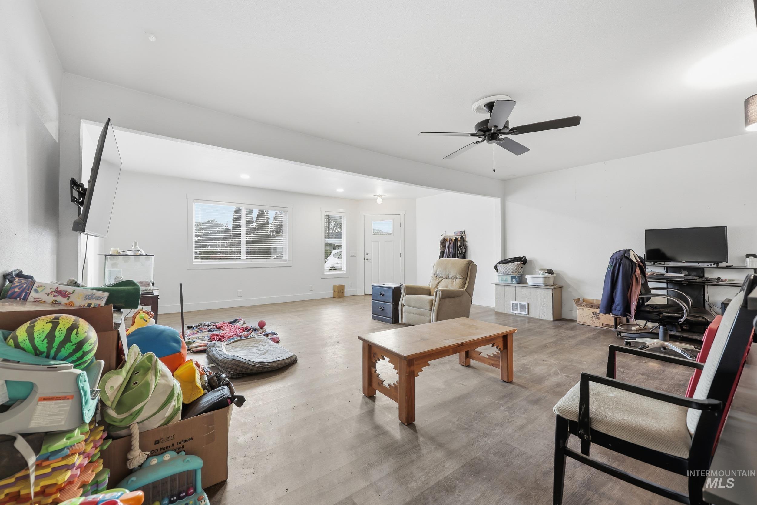 Living area with light wood finished floors, a desk, a ceiling fan, and recessed lighting